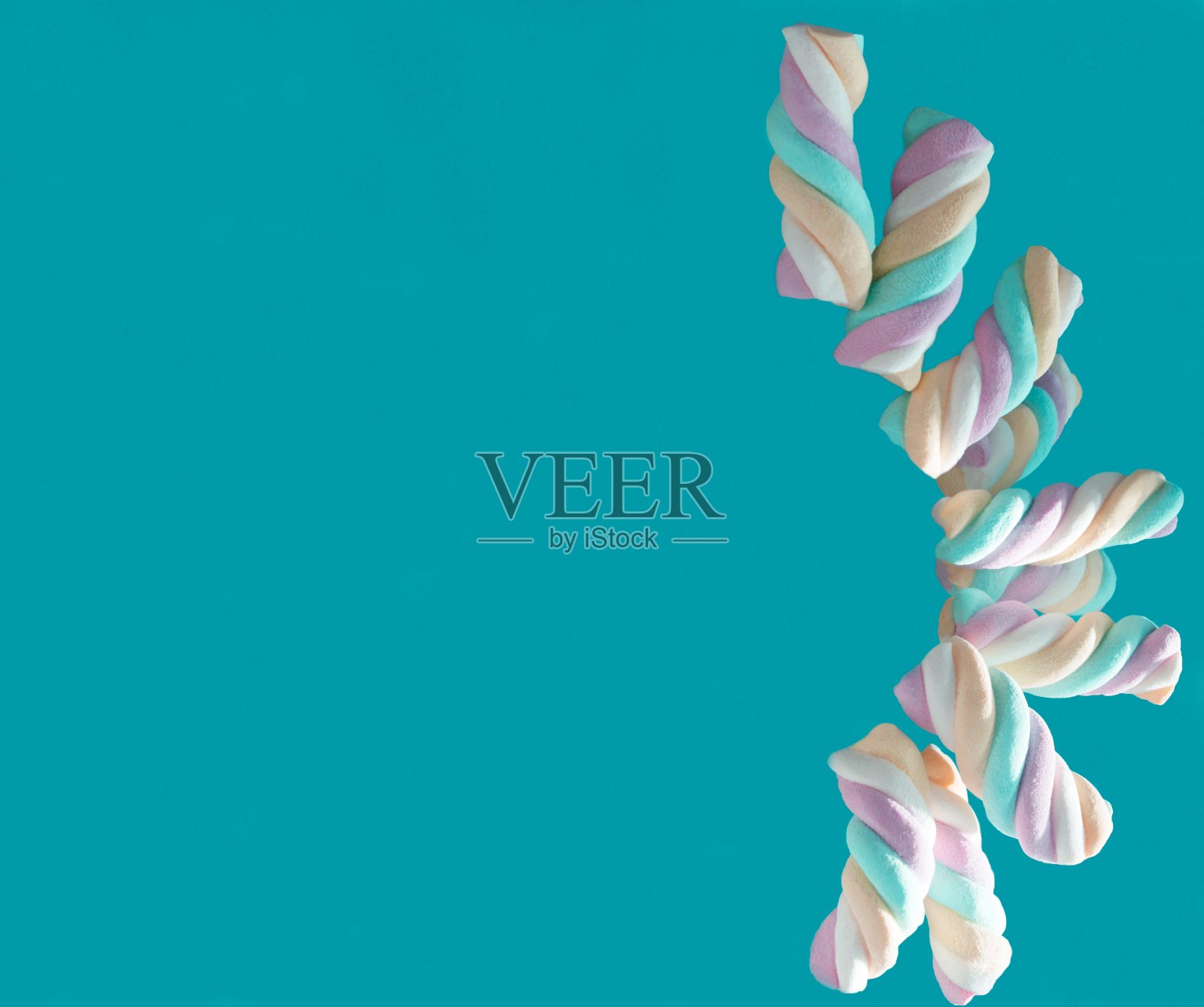 明亮,多色的棉花糖在阳光下的蓝色背景,垂直照片摄影图片