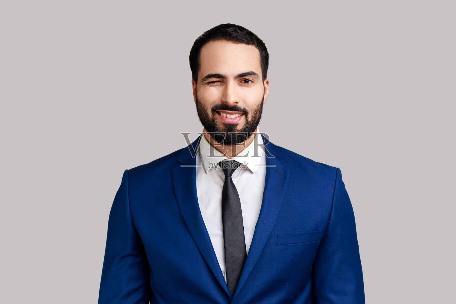 商人心情很好,咧着嘴笑,对着镜头眨着眼睛。照片摄影图片