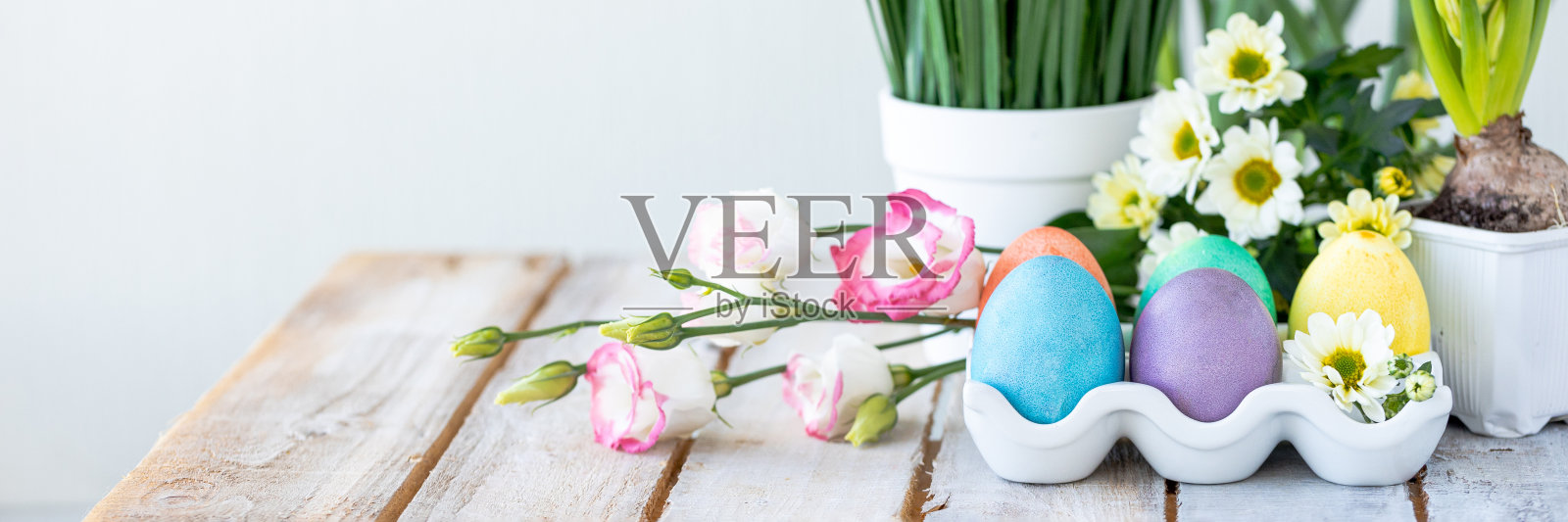 复活节构图,节日家居装饰。彩色的鸡蛋,白色的木桌上的花。文本横幅的复制空间照片摄影图片