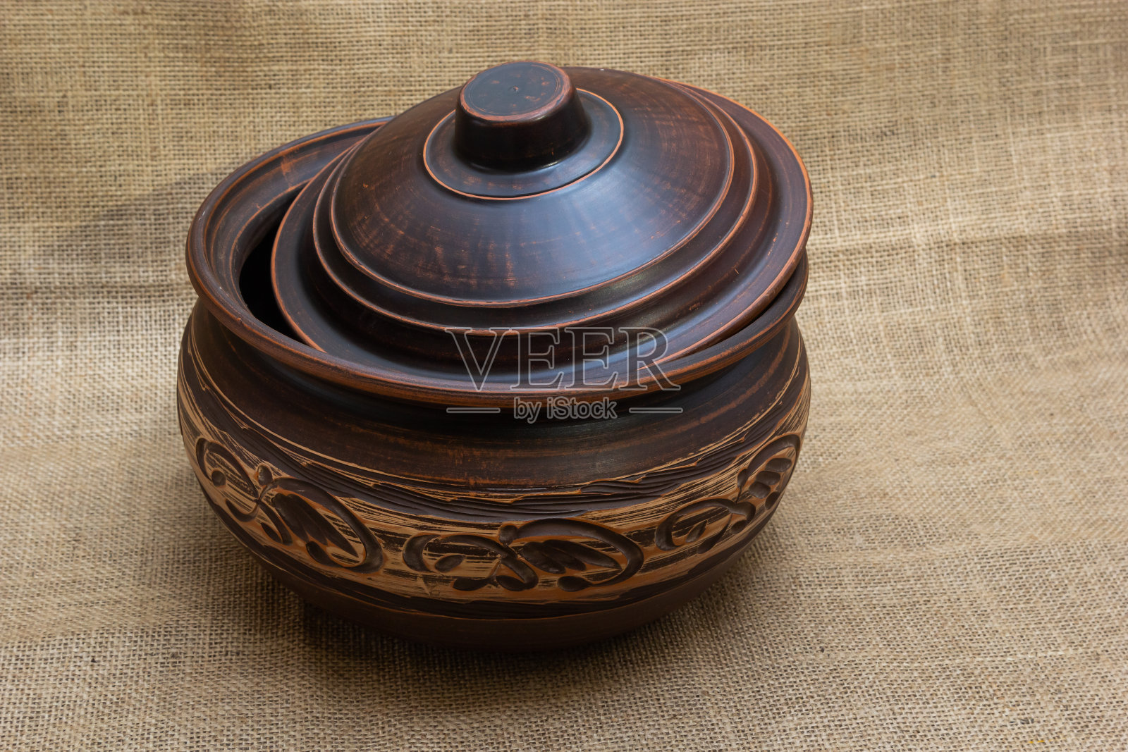 陶瓷餐具,橙棕色与白色图案的背景在织物的自然颜色照片摄影图片