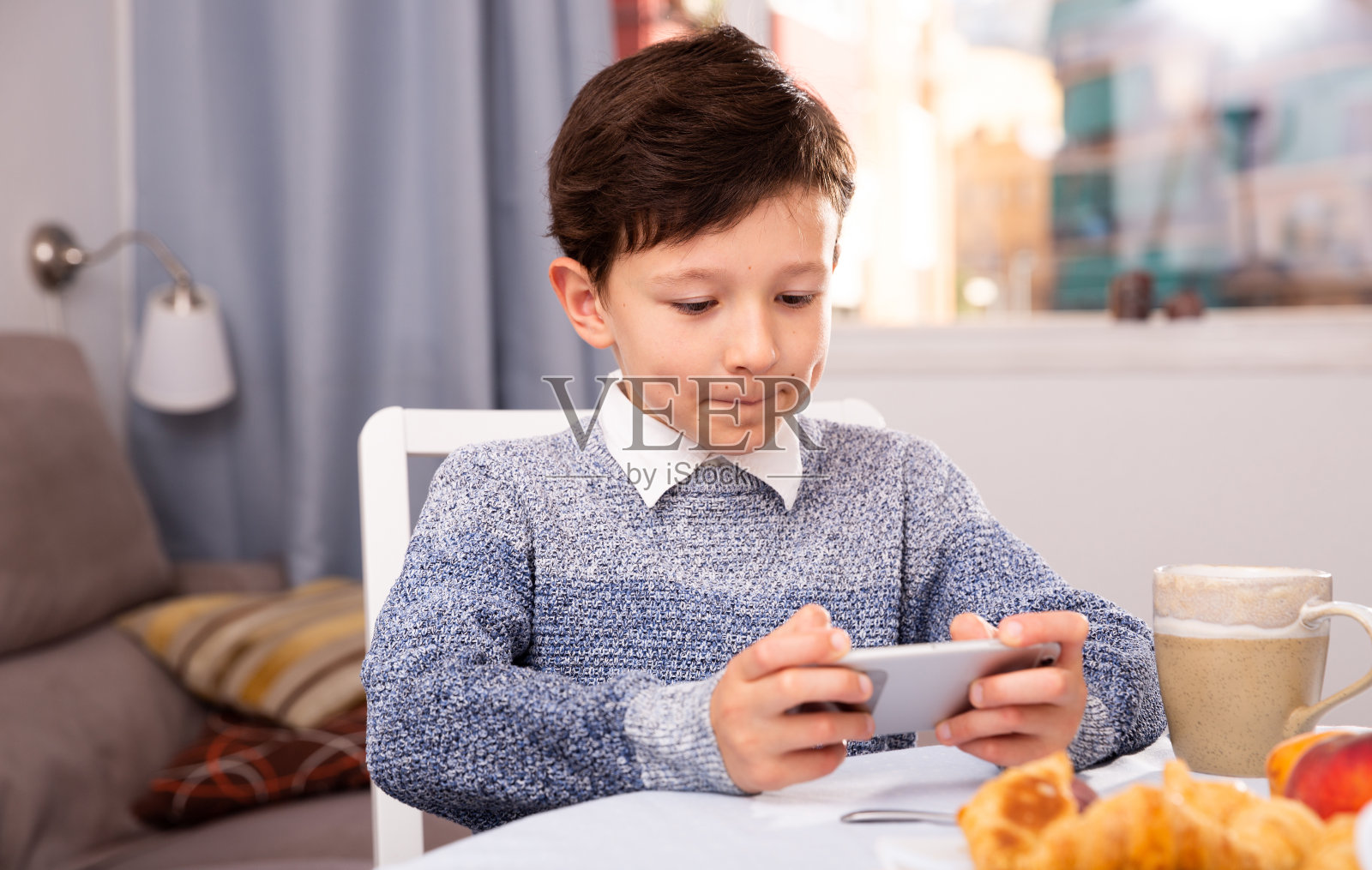 青少年在厨房室内玩智能手机照片摄影图片