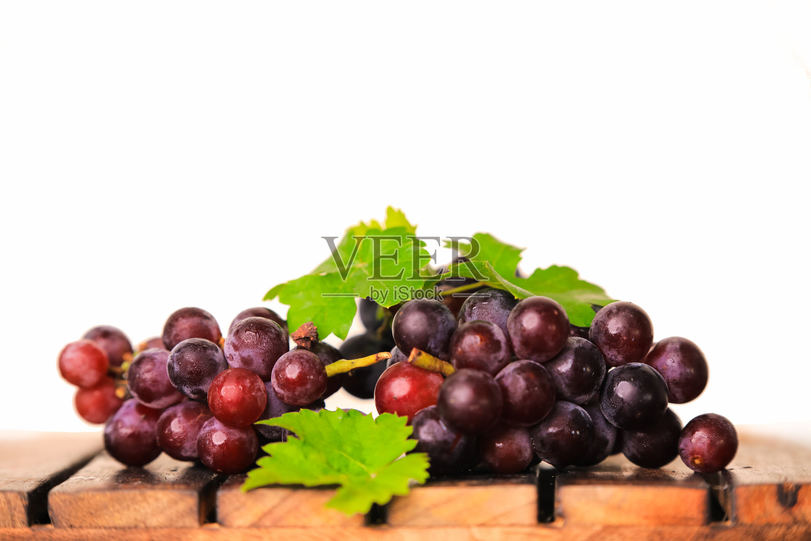 黑葡萄放在白色透明背景的木桌上照片摄影图片