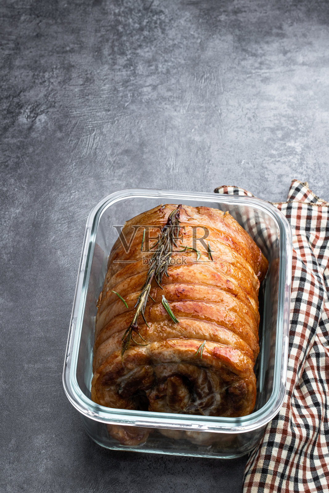 烤猪肉卷与香草和香料在灰色的石头背景照片摄影图片