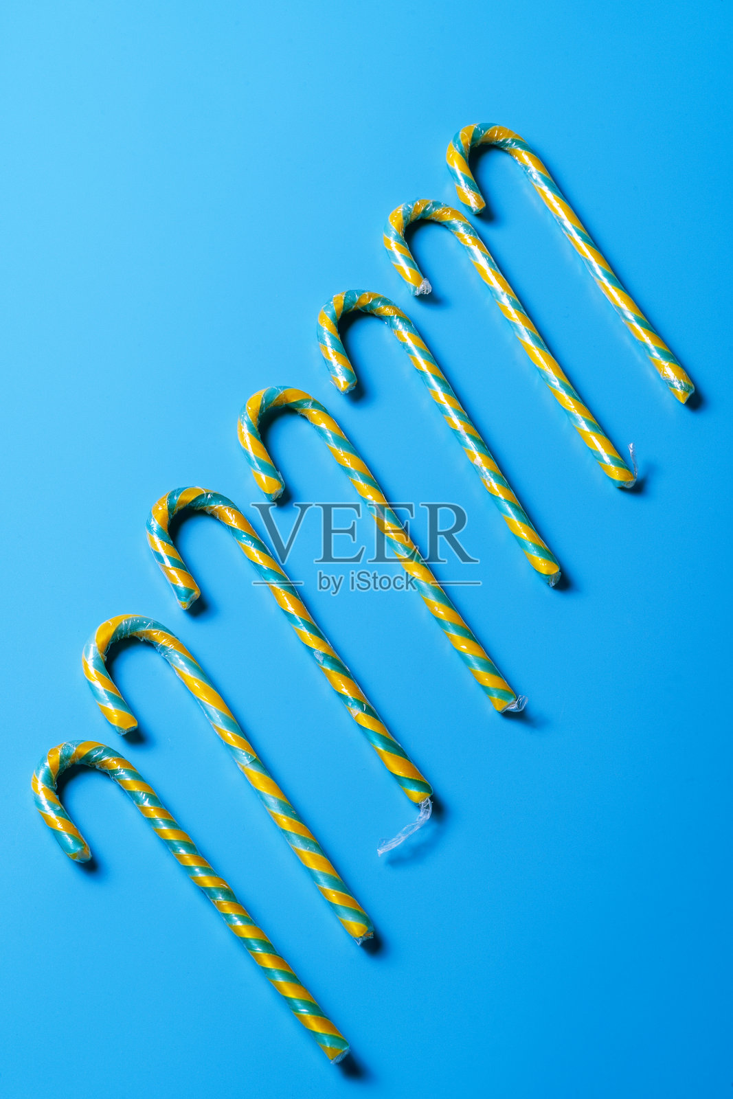 平坦的糖果藤排在蓝色柔和的背景。照片摄影图片
