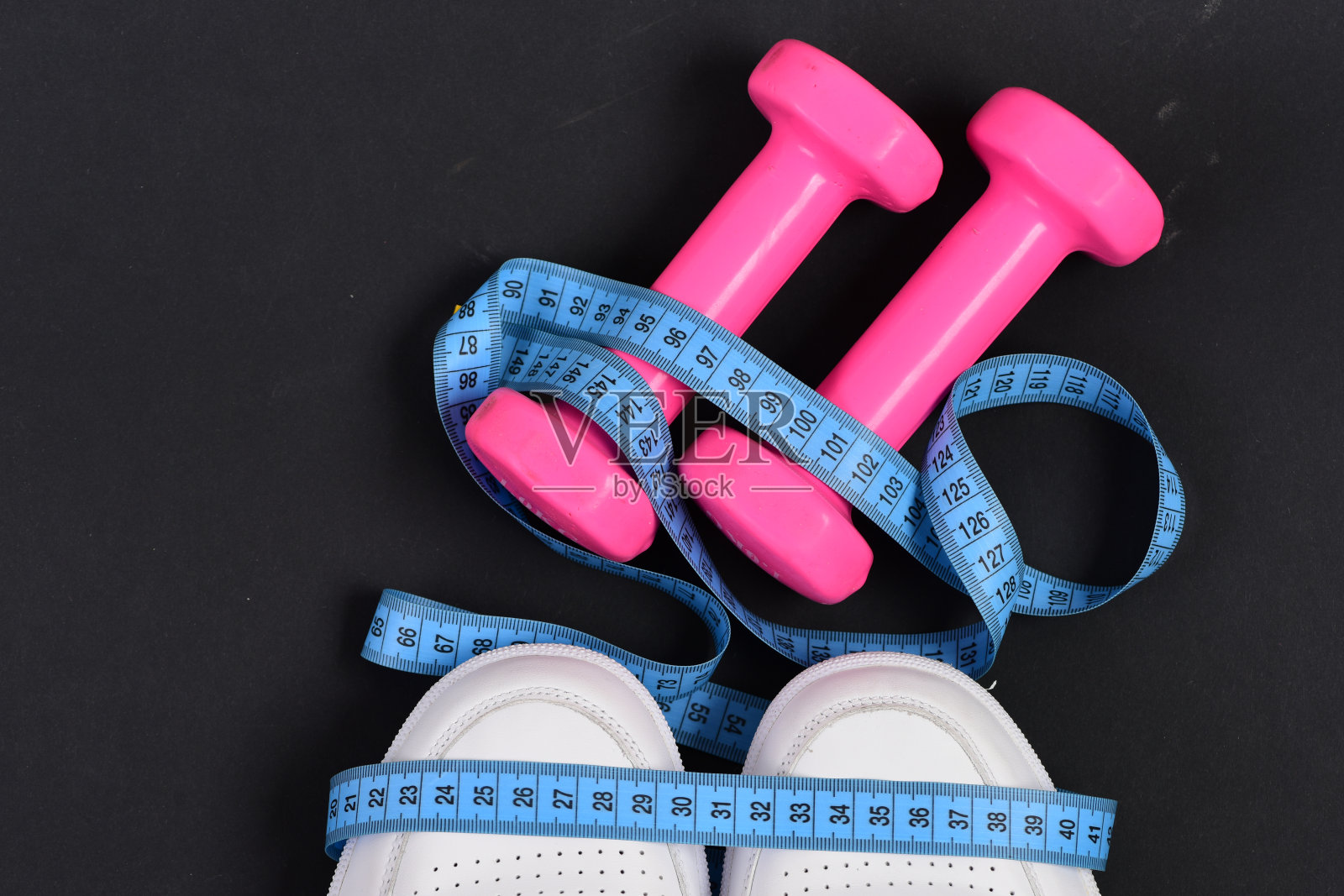 健身器材。粉色的哑铃,卷尺照片摄影图片