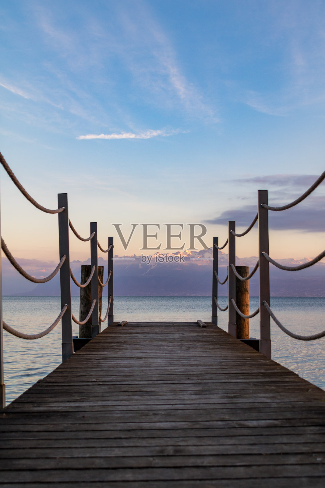 木浮桥在日落时分开放在摩尔赫斯日内瓦湖岸边的雪山(瑞士沃州)照片摄影图片