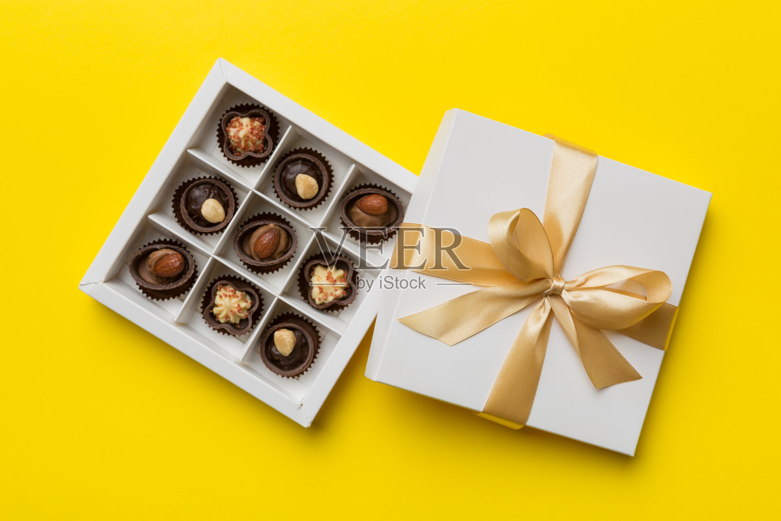 白色盒子,里面装着巧克力、糖果和金色的胶带。顶部视图与复制空间照片摄影图片