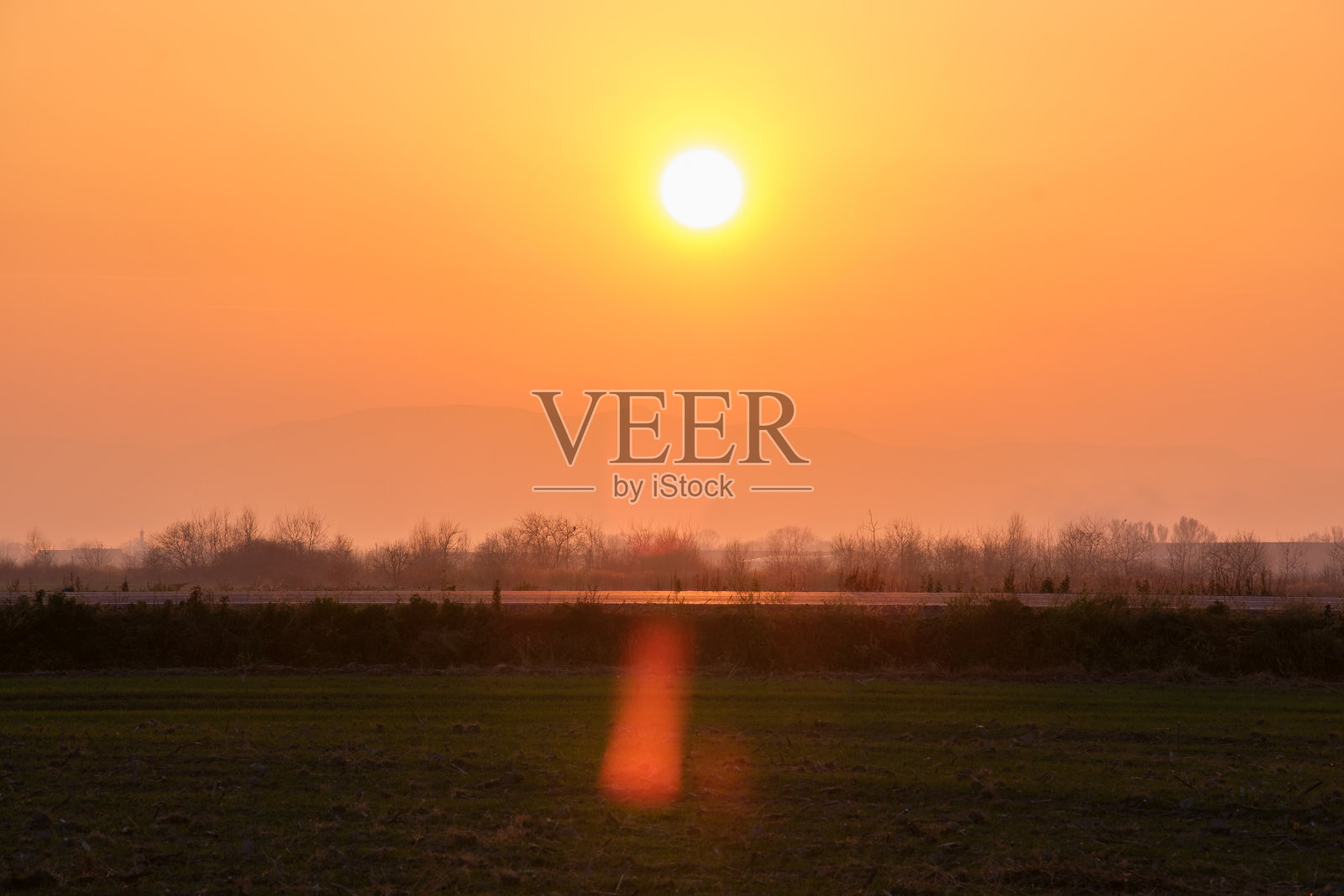 美丽的傍晚全景,明亮的夕阳越过遥远的山峰和沥青道路在日落前照片摄影图片