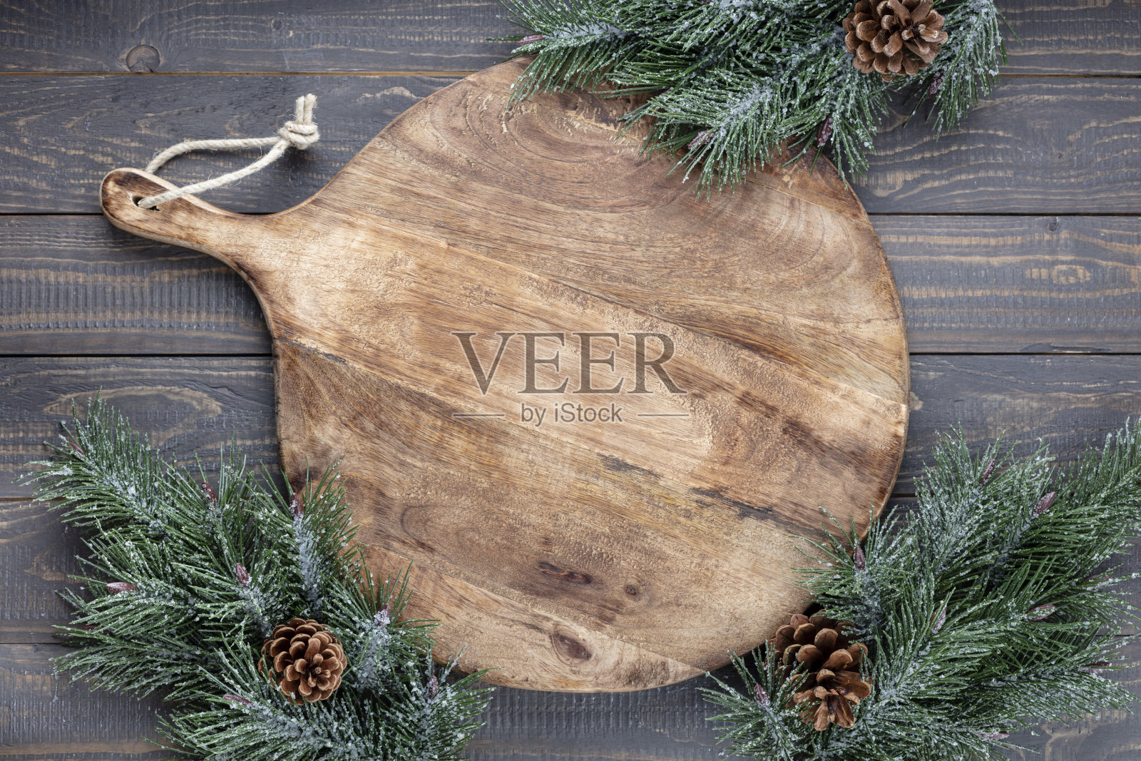 一块空的切菜板放在旧的圣诞餐桌上。照片摄影图片