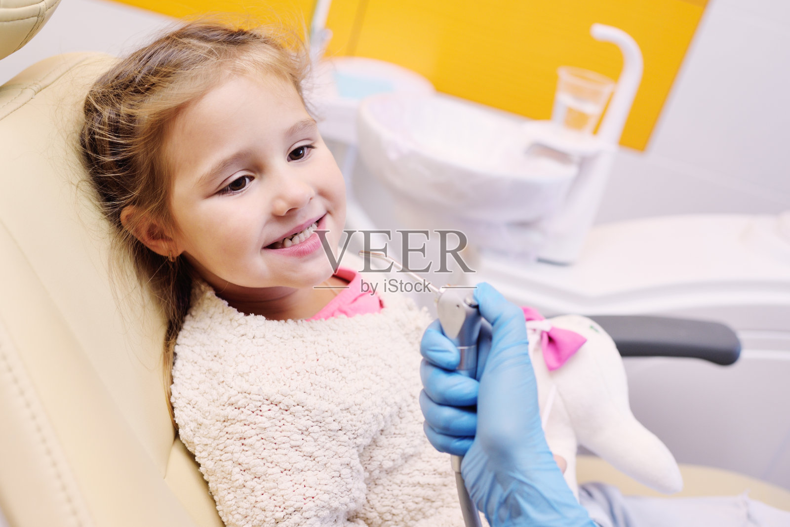 小女孩坐在牙科椅上照片摄影图片