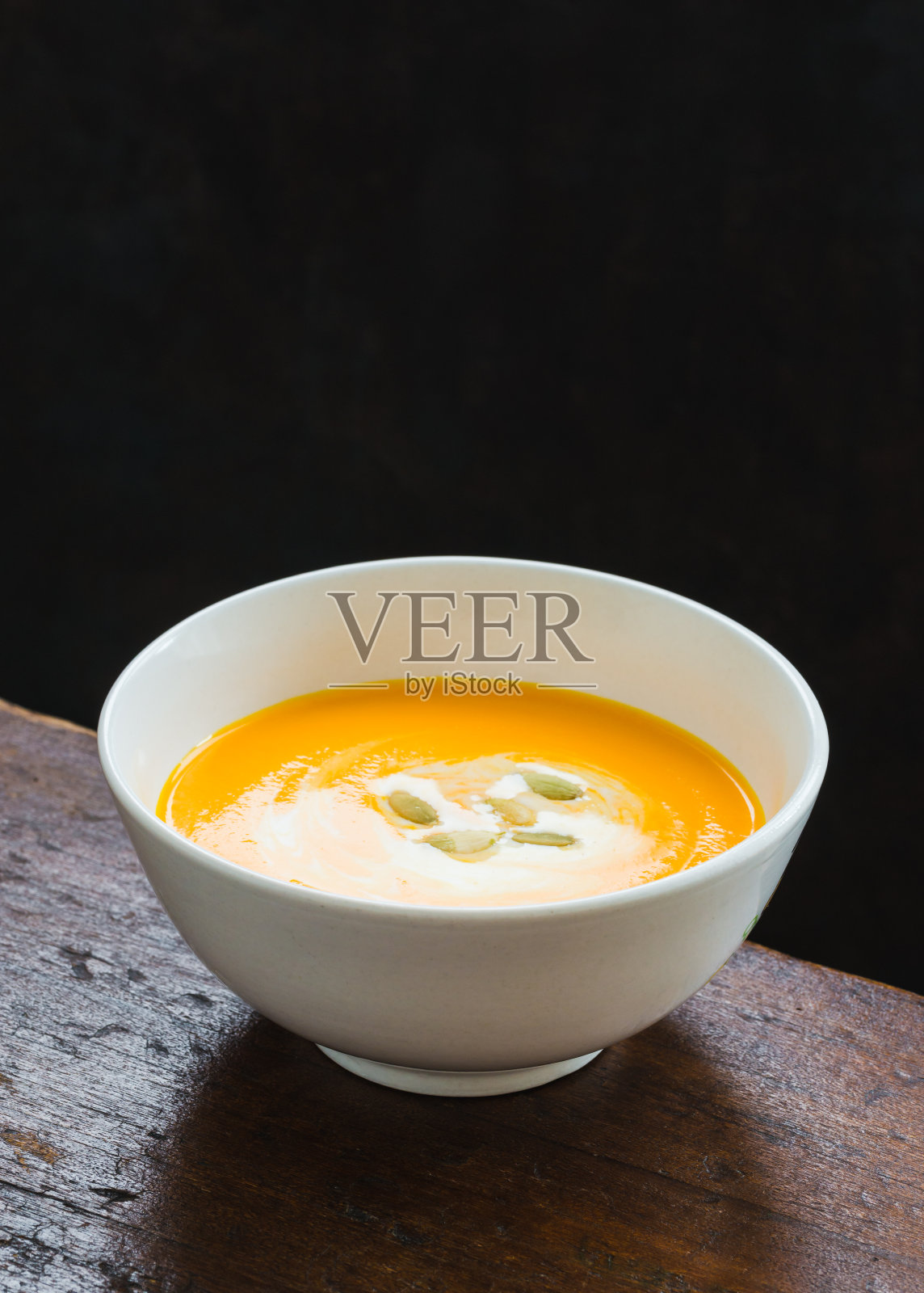 南瓜奶油汤在黑暗的背景。照片摄影图片