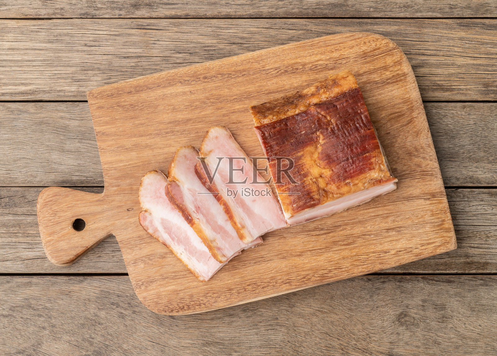在木板上切成薄片的烟熏培根照片摄影图片