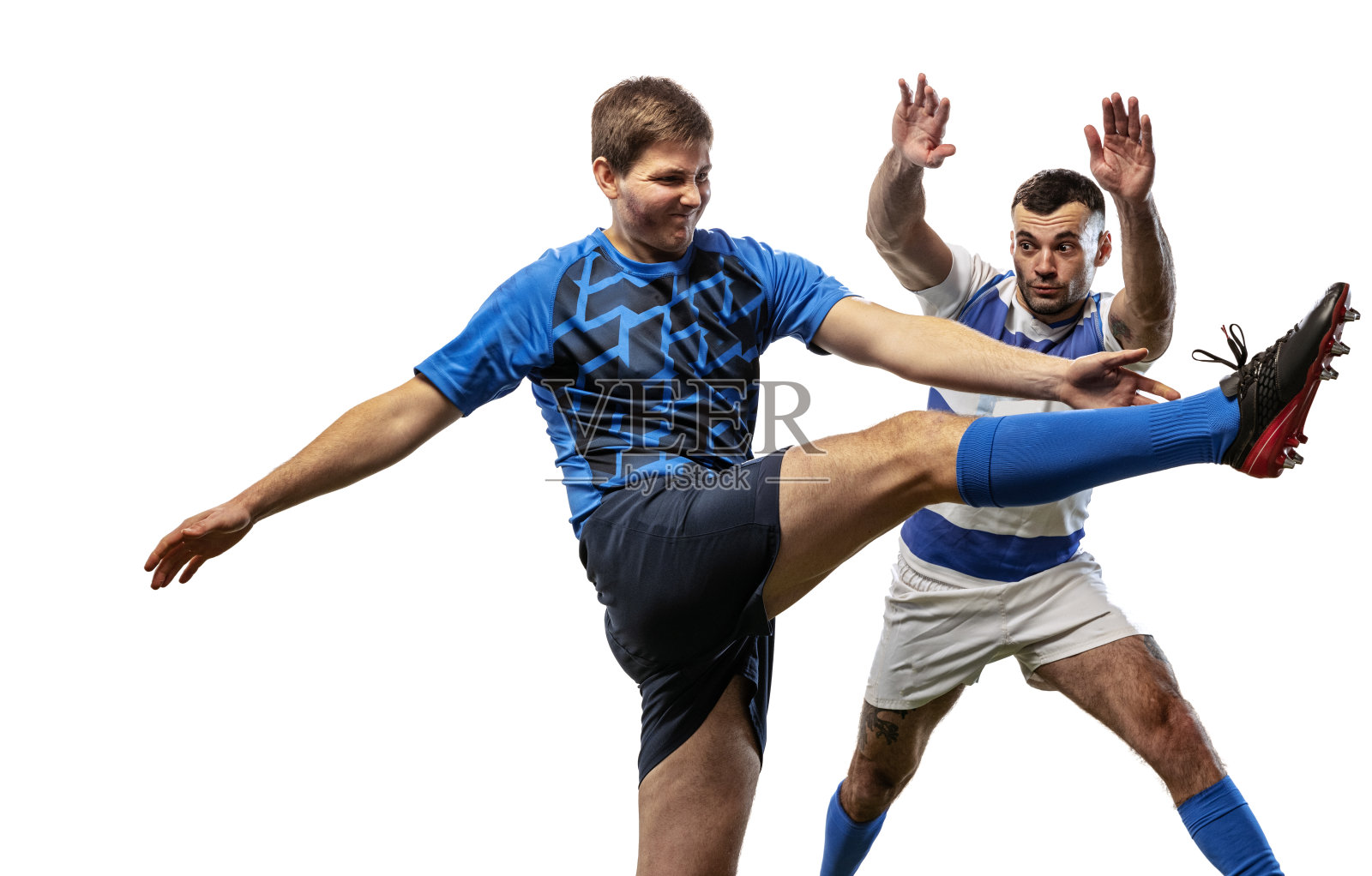 两名橄榄球运动员在白色背景的草地上踢橄榄球。运动,活动,健康,爱好,职业概念照片摄影图片