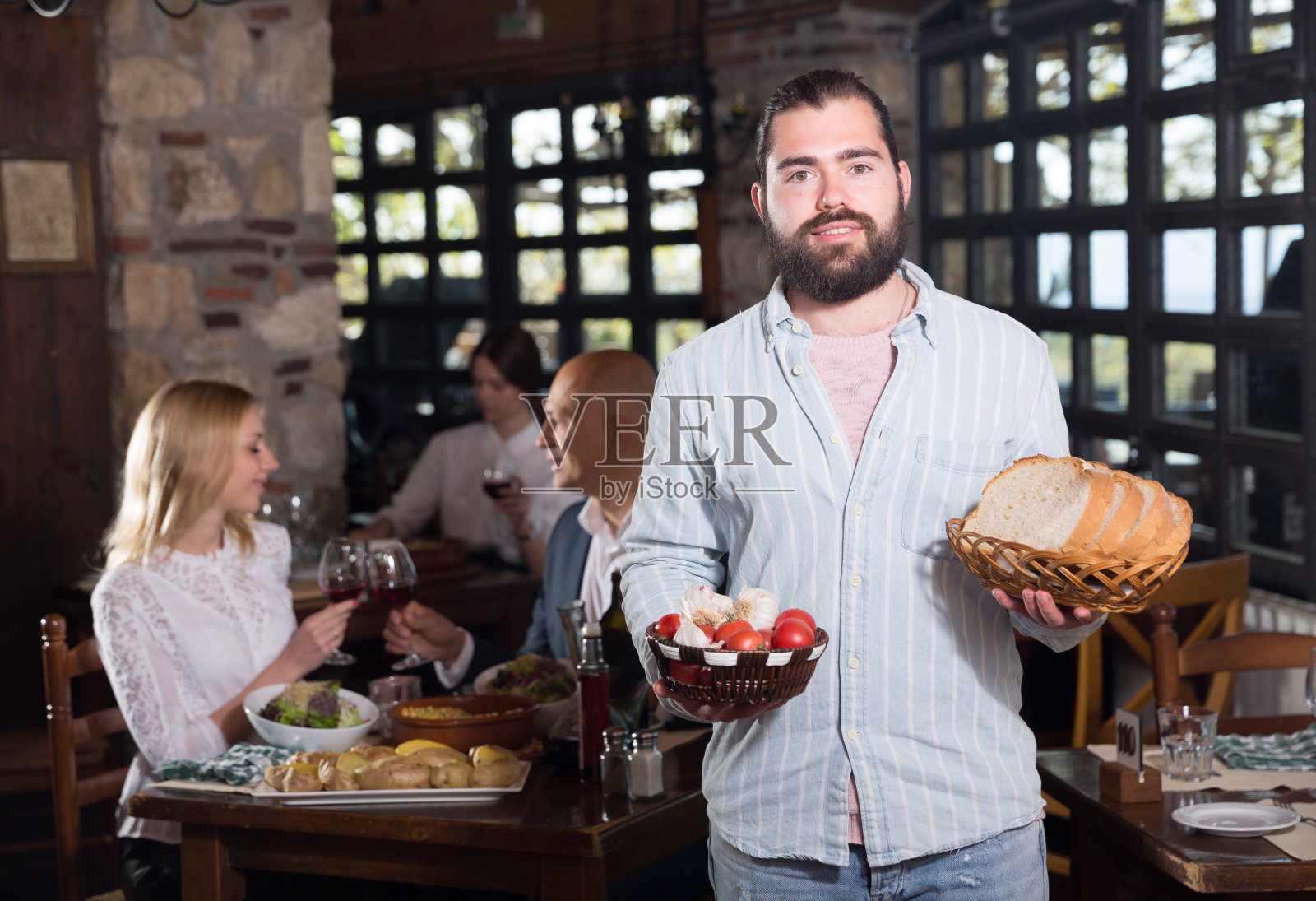 留着胡子的侍者端着菜来品尝照片摄影图片