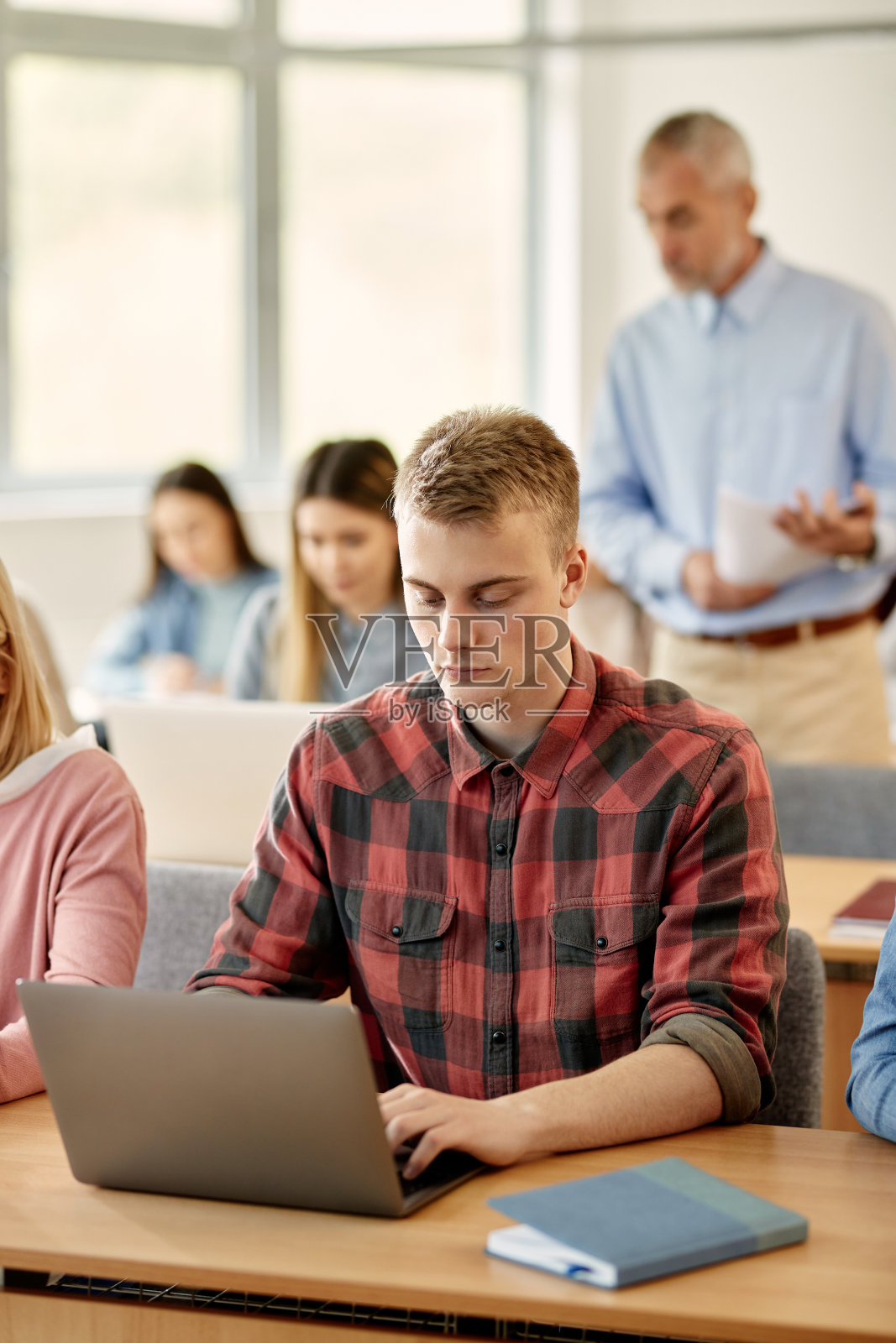 年轻的学生在课堂上用笔记本电脑进行在线学习。照片摄影图片