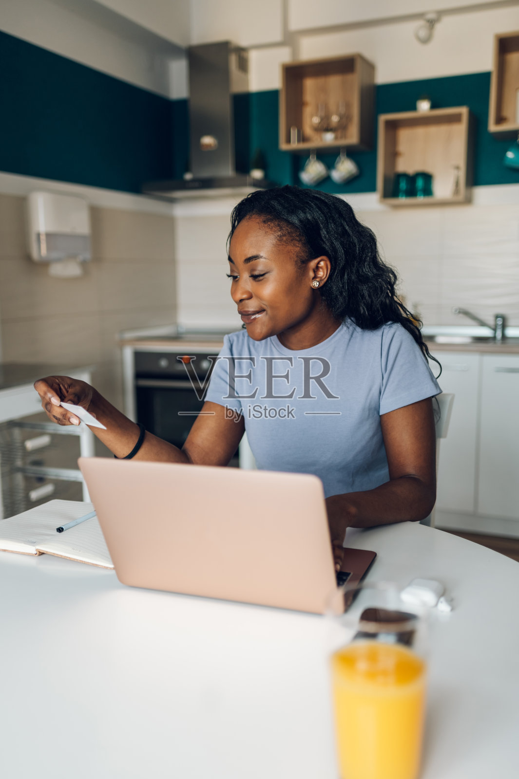 非裔美国妇女在家里使用笔记本电脑和信用卡照片摄影图片