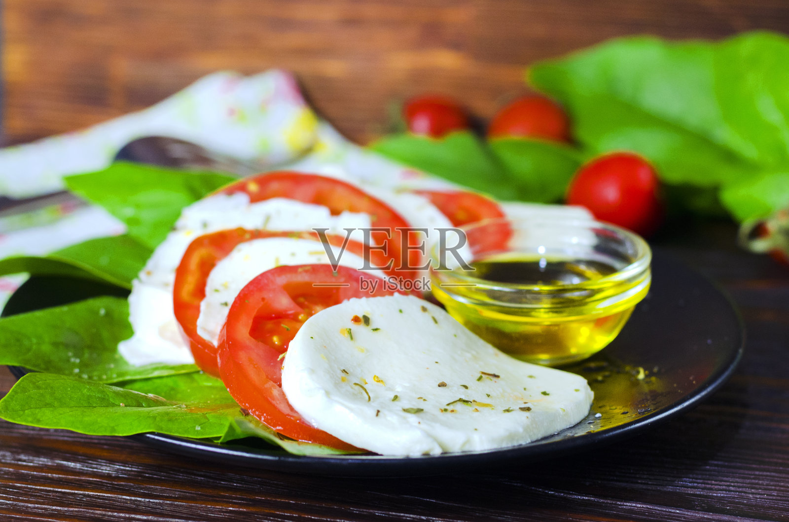 马苏里拉奶酪沙拉,新鲜番茄,菠菜和罗勒。照片摄影图片