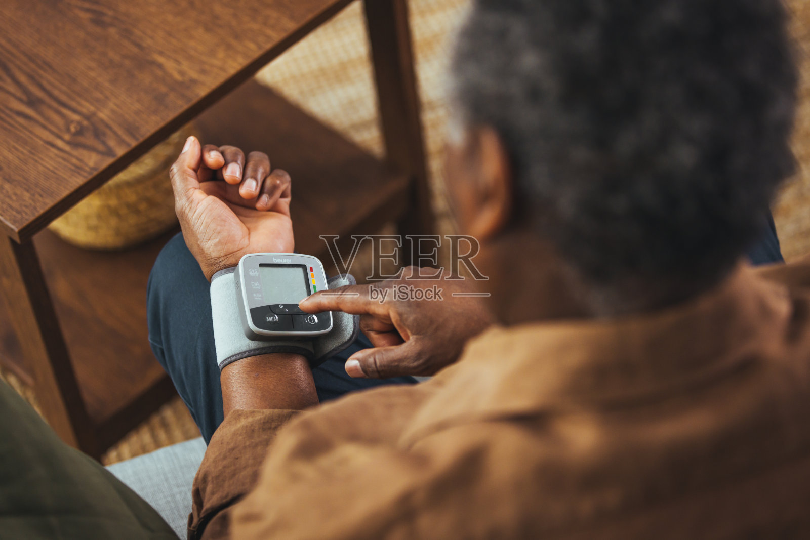 一个老人独自坐在家里。照片摄影图片