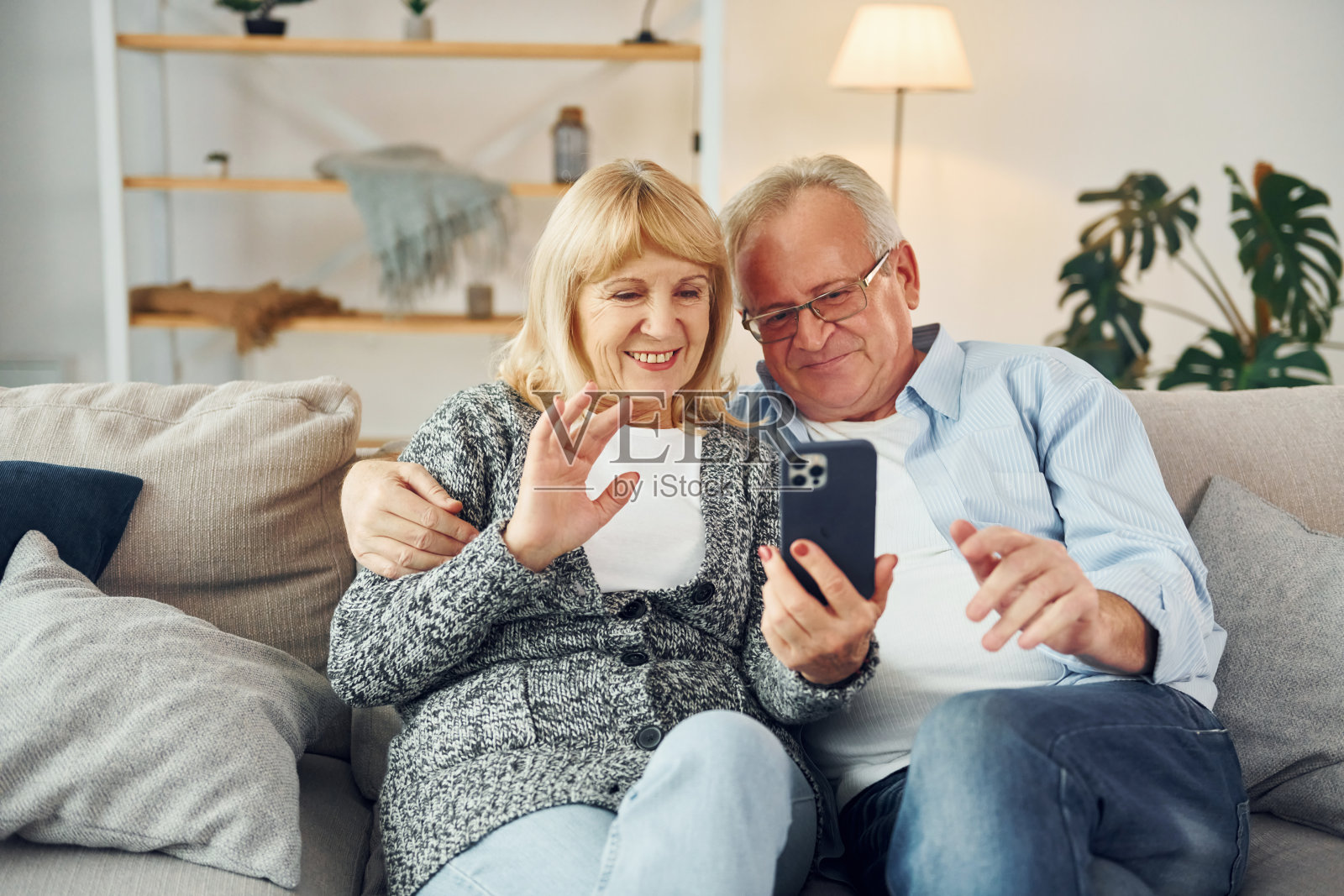 坐在沙发上。男长辈和女长辈一起在家照片摄影图片