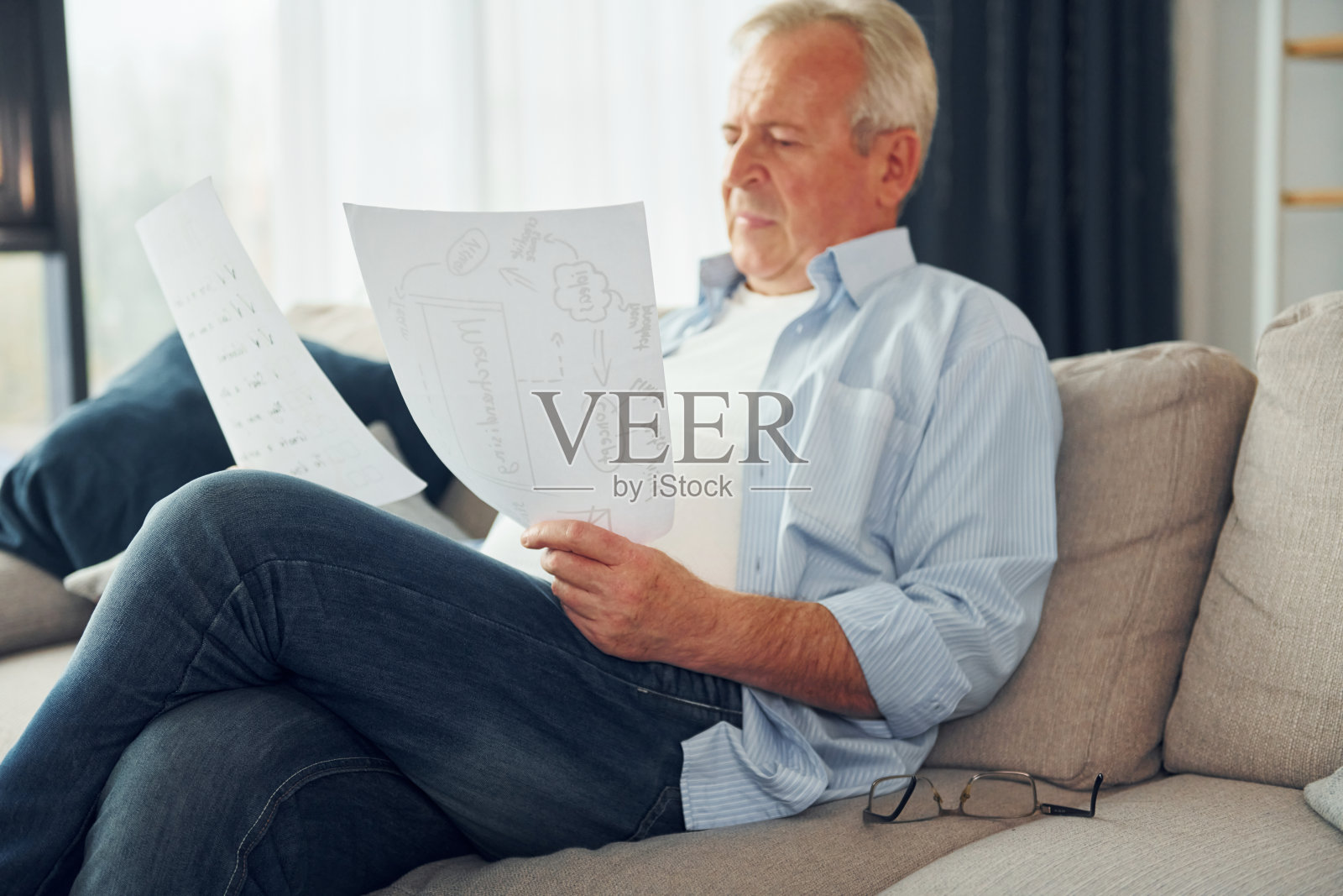 两篇论文。穿着漂亮衣服的老先生在家照片摄影图片