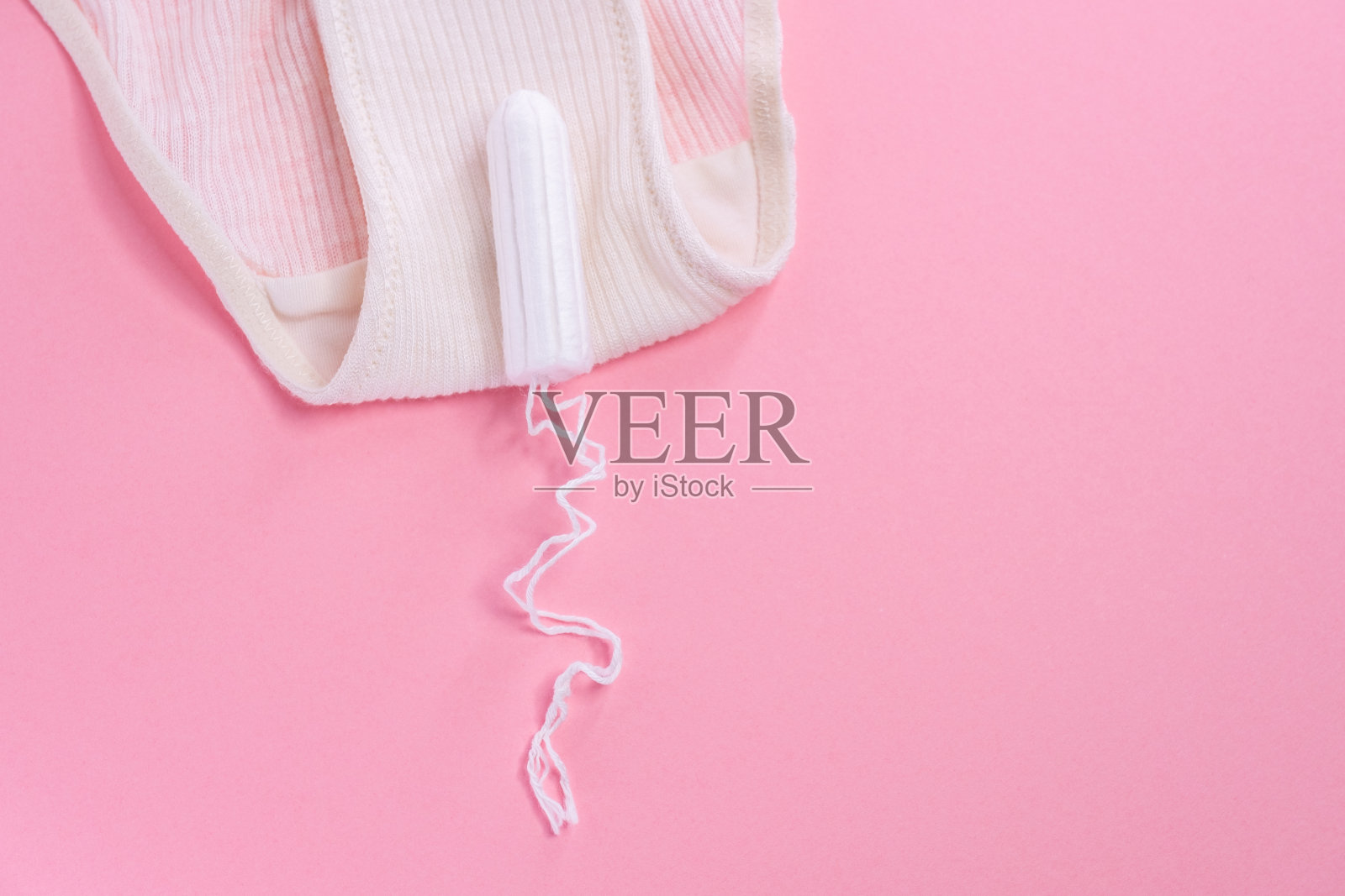 粉红色背景的女性卫生棉条。照片摄影图片