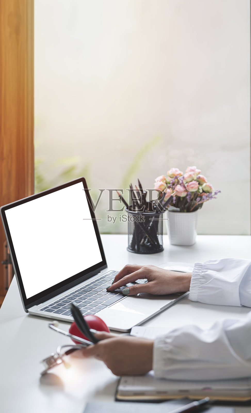 在线医疗咨询——医生在诊所办公室用笔记本电脑工作。副本的空间。照片摄影图片