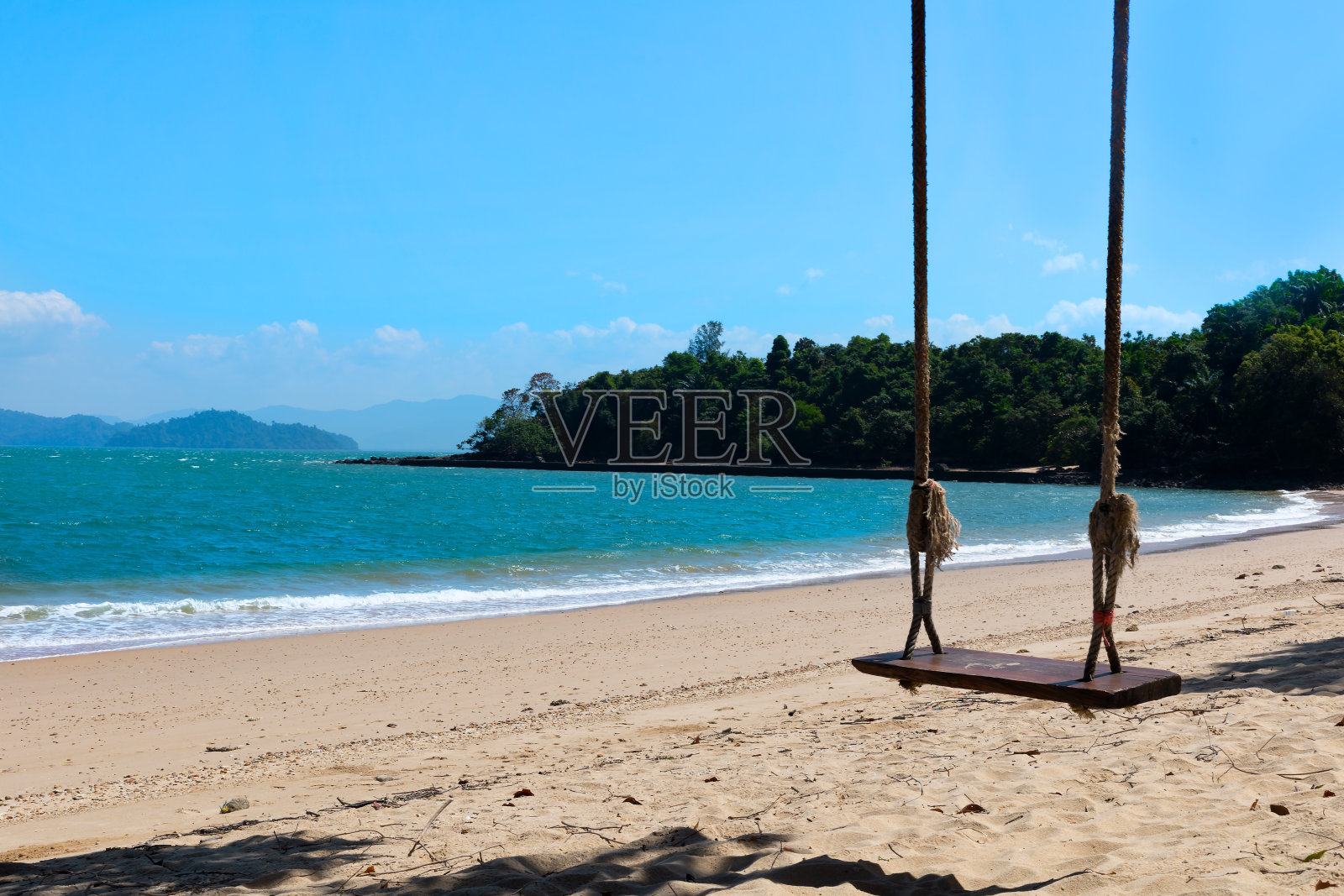一个小木秋千挂在树上,在泰国南部的海滩上,度假概念,在海滩上度假。照片摄影图片