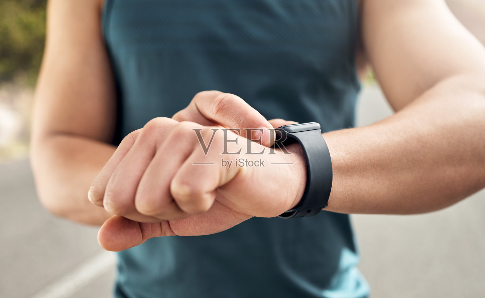 一个男人在外面跑步时看手表的照片照片摄影图片