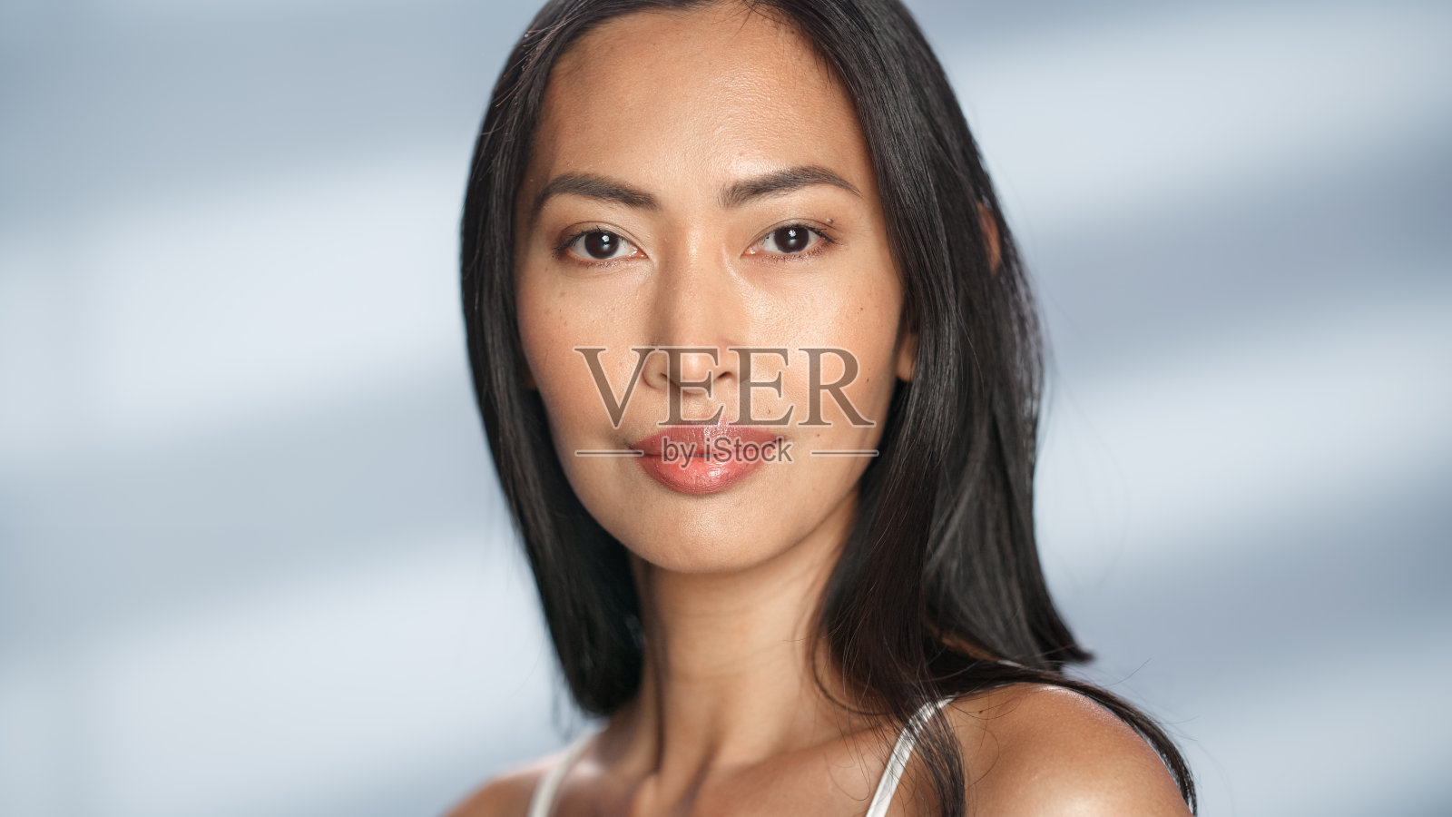 女性美丽的肖像。美丽多样的亚洲黑发女人摆姿势,微笑,触摸她的脸与自然,健康的皮肤。柔软孤立背景下的健康护肤理念。关闭了。照片摄影图片