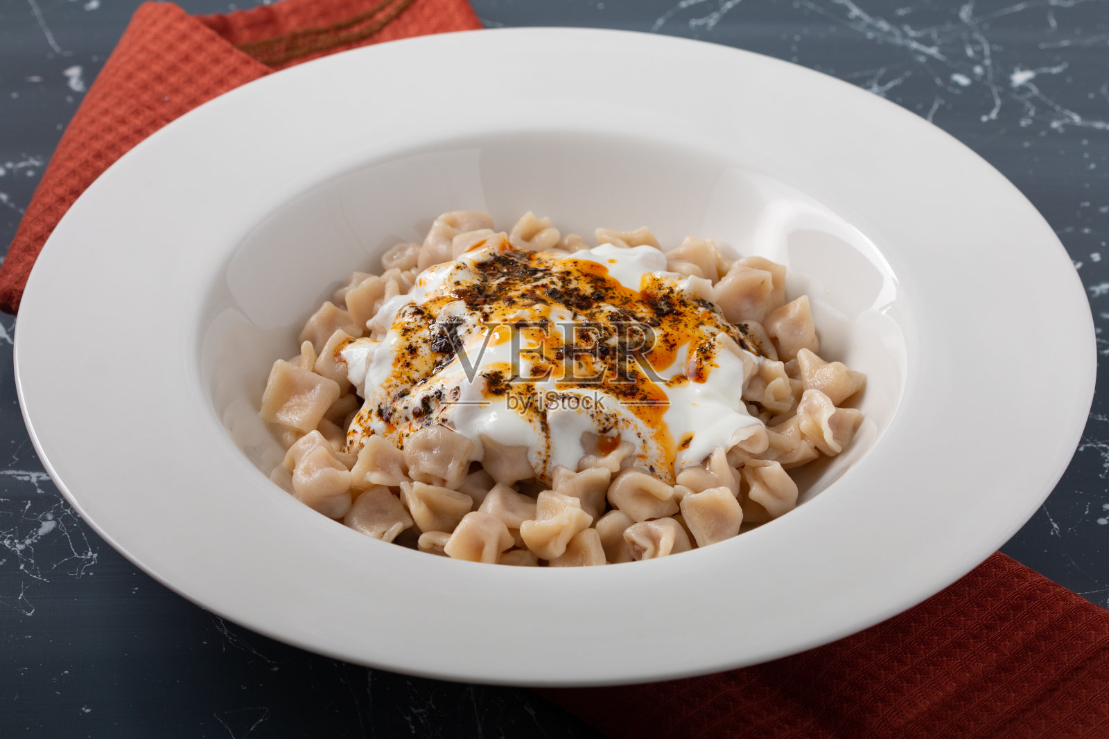 意大利饺子,土耳其饺子,mantı,肉末,土耳其意大利面,意大利面,黄油和酸奶。照片摄影图片