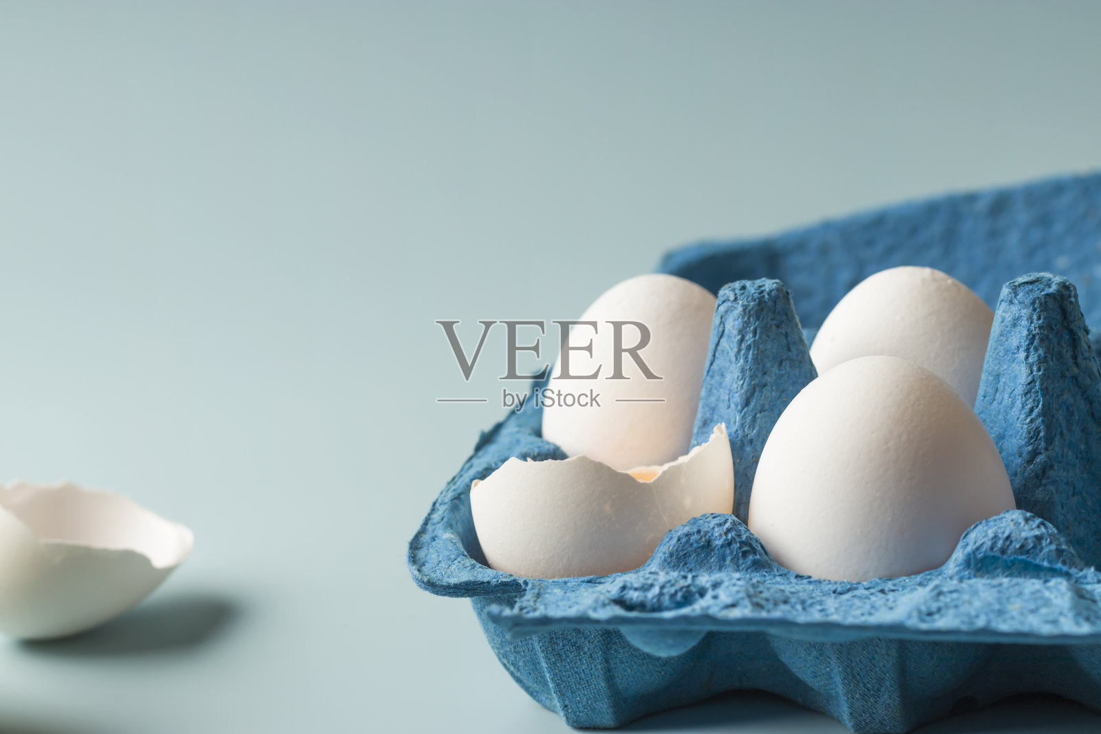 在蓝色背景上的新鲜鸡蛋生态包装的特写。农场的天然产品。本空间照片摄影图片
