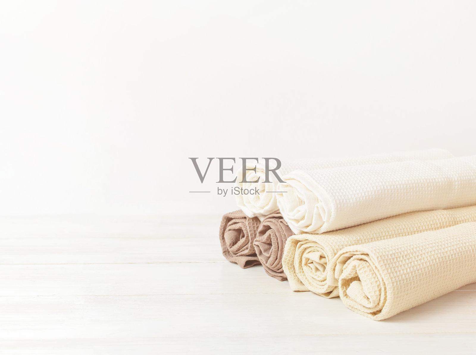 彩色干净的毛巾在轻木制背景与复制空间。质地棉,华夫格毛巾,纺织品。厨房或水疗浴巾概念。照片摄影图片