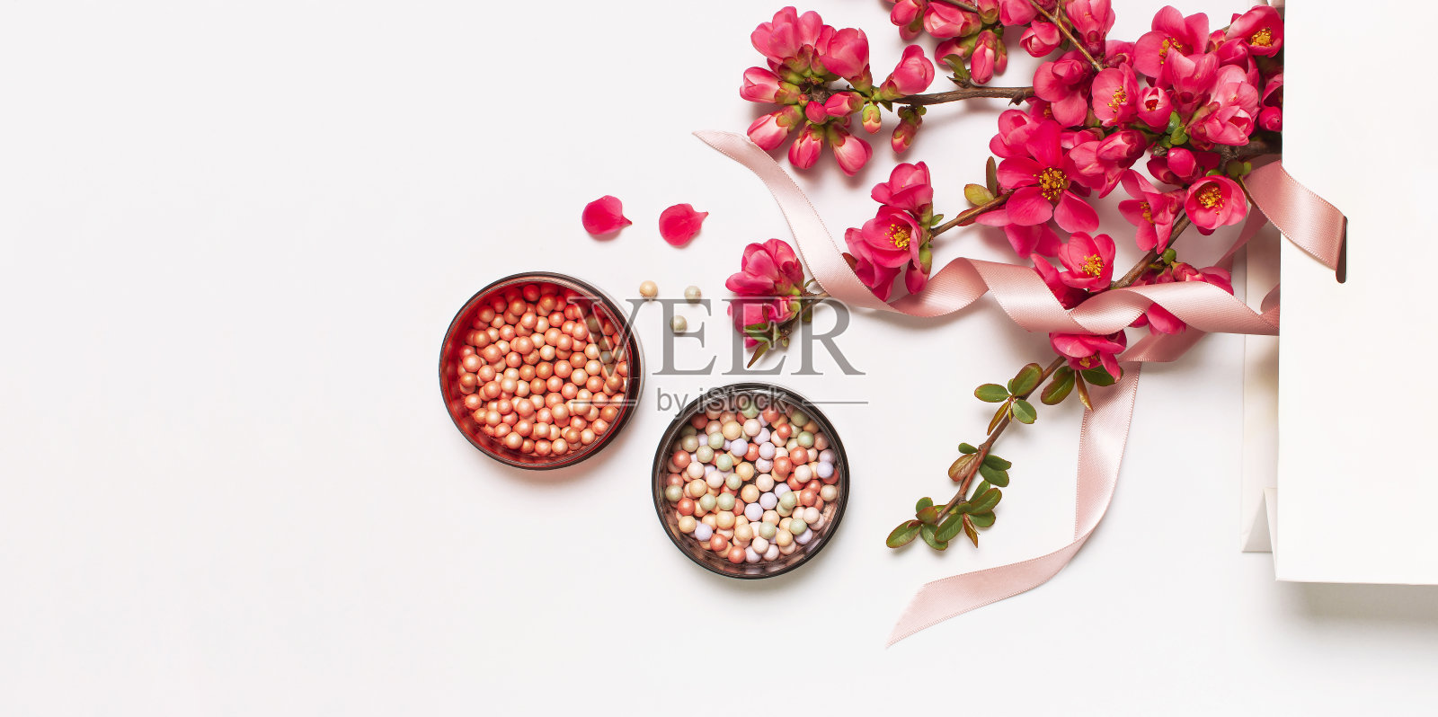 球腮红胭脂和面粉,化妆刷,春天粉红花在白色礼品包在光背景顶视图平躺。不同的妆化妆品。美妆时尚背景购物概念照片摄影图片