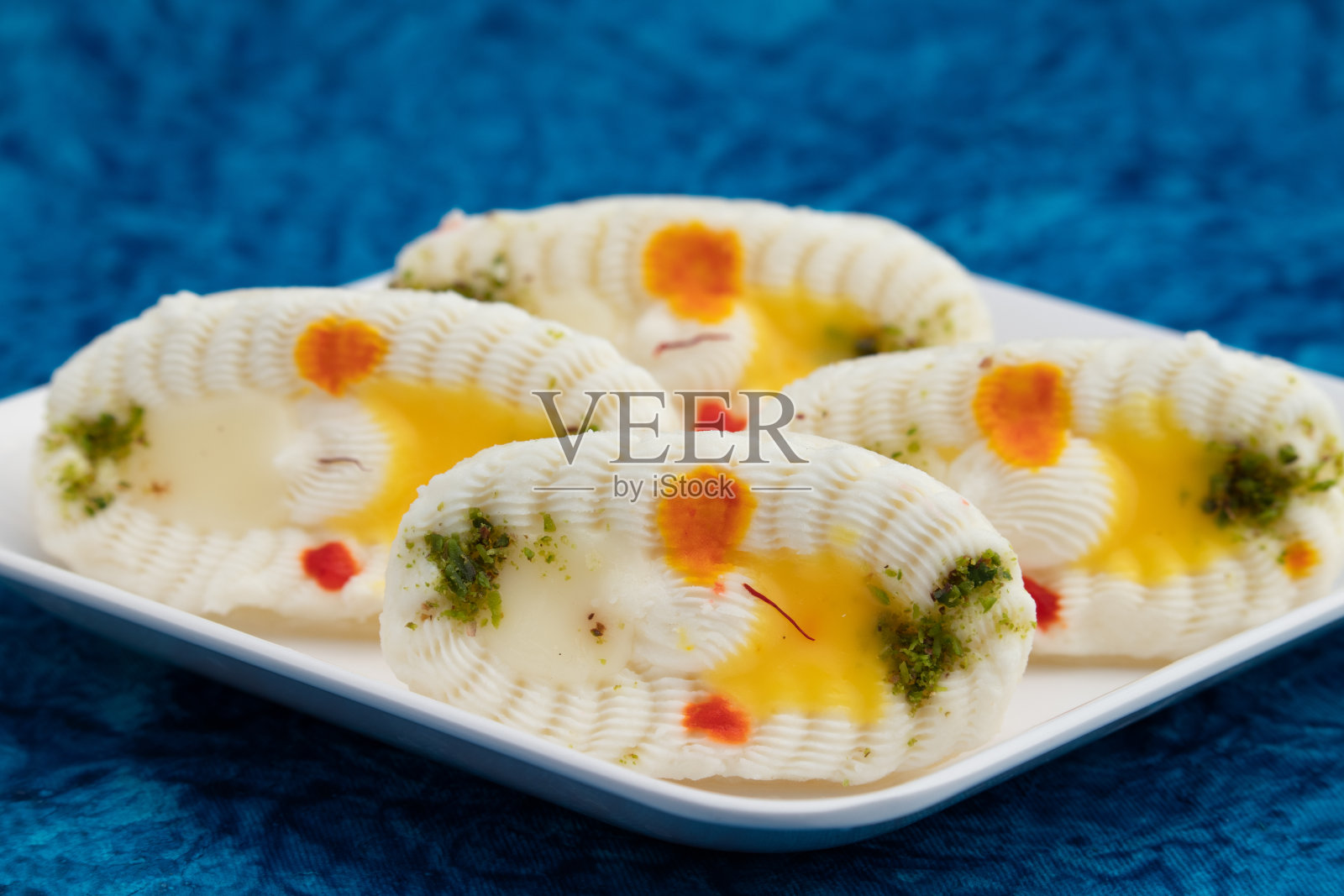 Cham Cham Mithai也被称为Rasgulla Malai Chaap, Chomchom或Rosogolla Chamcham是由牛奶,Mawa, Khoya, Pista, Kesar, Khova, Paneer, Chenna, Chhena,干果馅料和浸在Chasni照片摄影图片