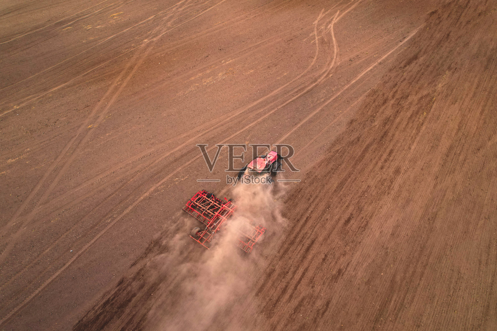 田间栽培,鸟瞰图。带圆盘耙的拖拉机。耕地耕过,土壤耕过。照片摄影图片