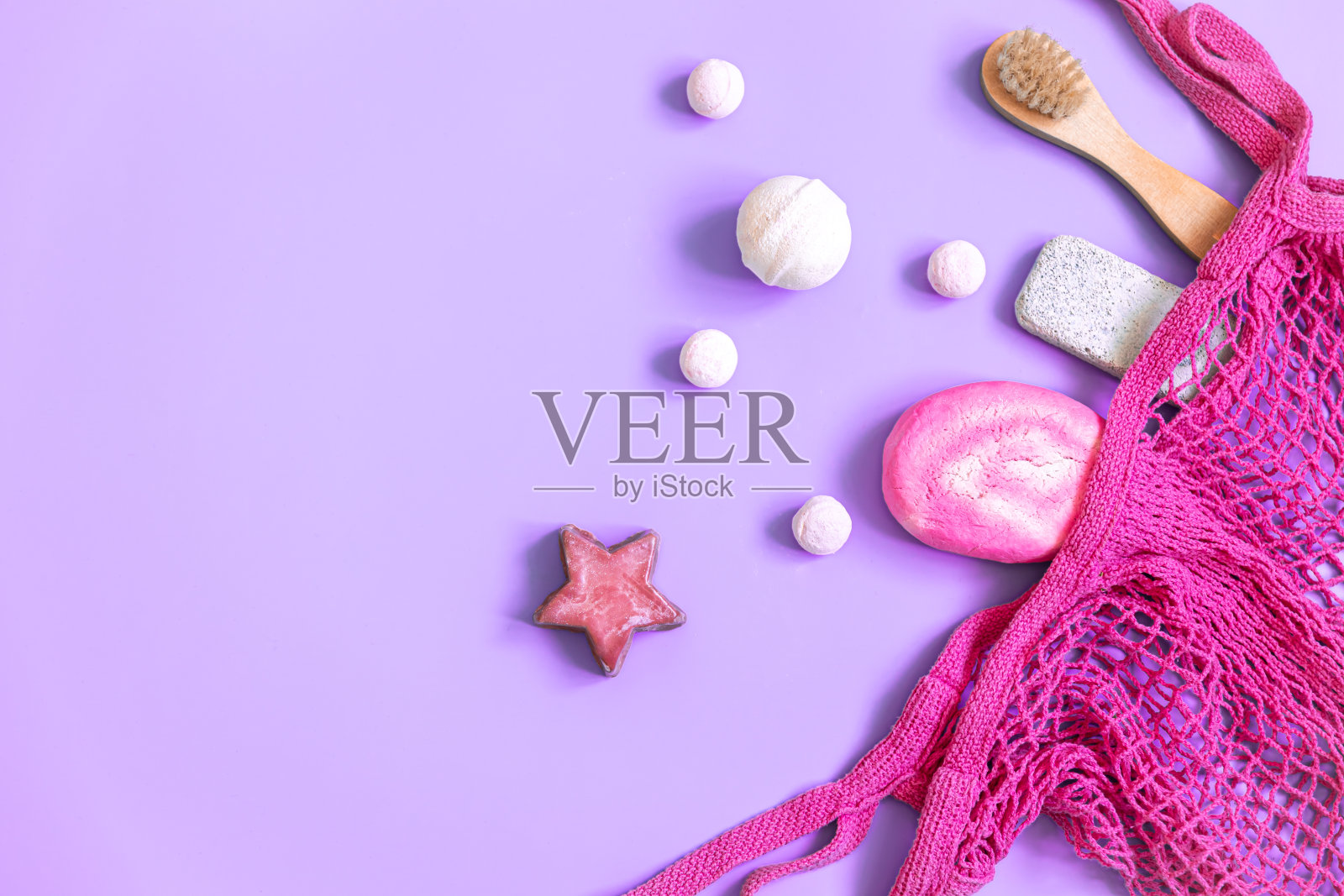 水疗组成与沐浴配件在一个粉红色的绳袋,平躺。照片摄影图片