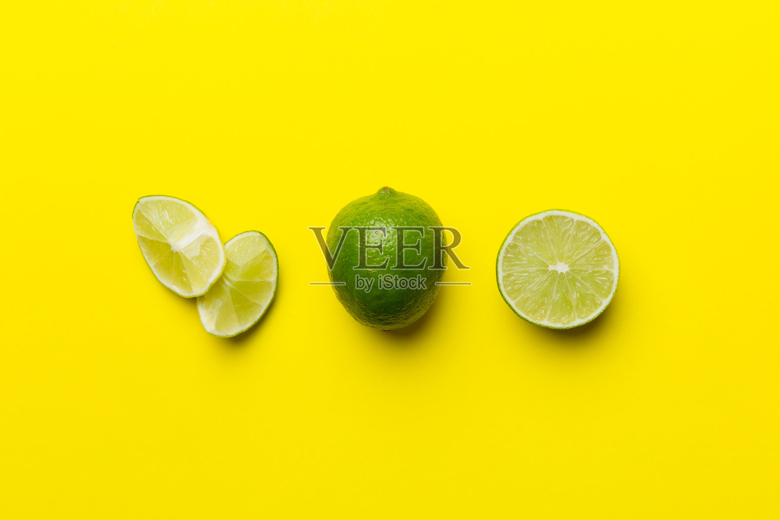 青柠果,绿叶,切成半片,白色背景。前视图。平铺与复制空间照片摄影图片