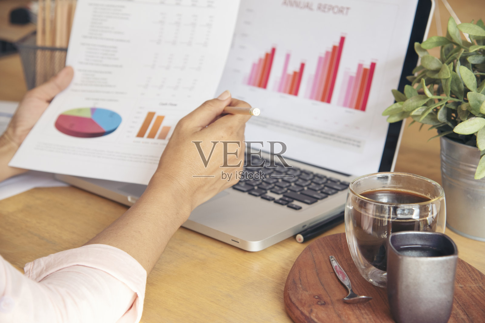 商务女性在办公桌上使用智能手机和笔记本电脑。计划分析市场数据。年轻女性的手在办公室工作,公司的业务信息。照片摄影图片