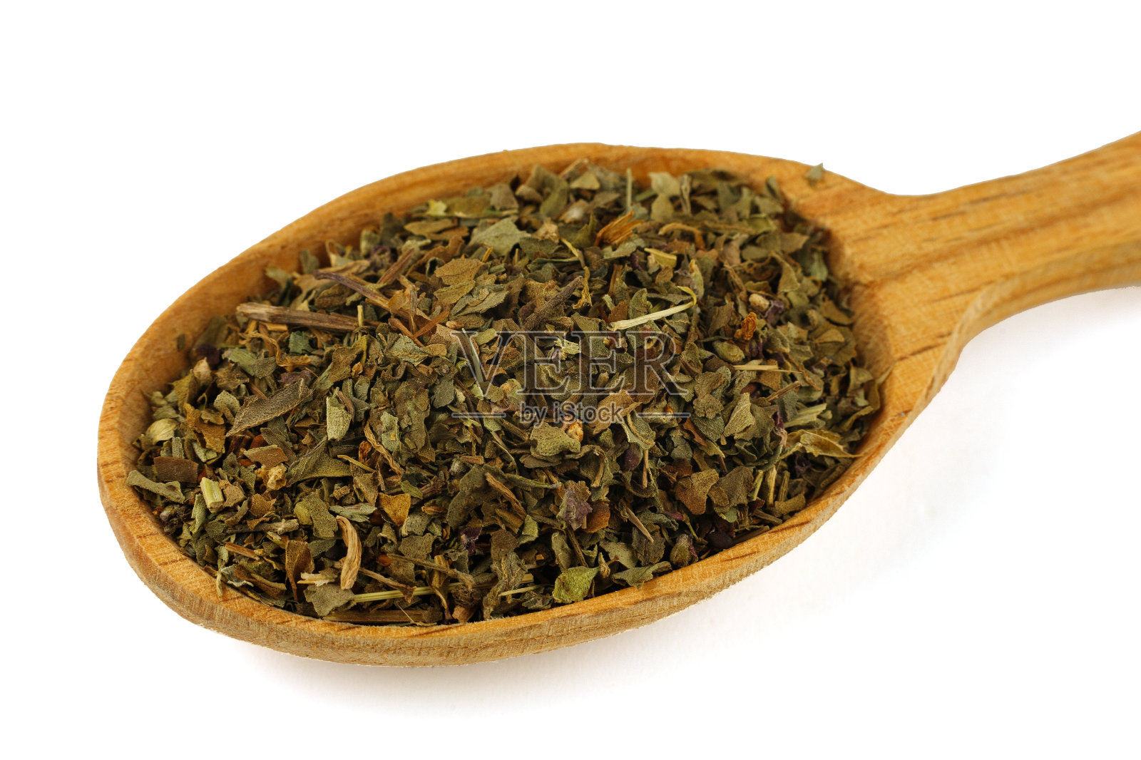 用木勺放入干罗勒调味料照片摄影图片