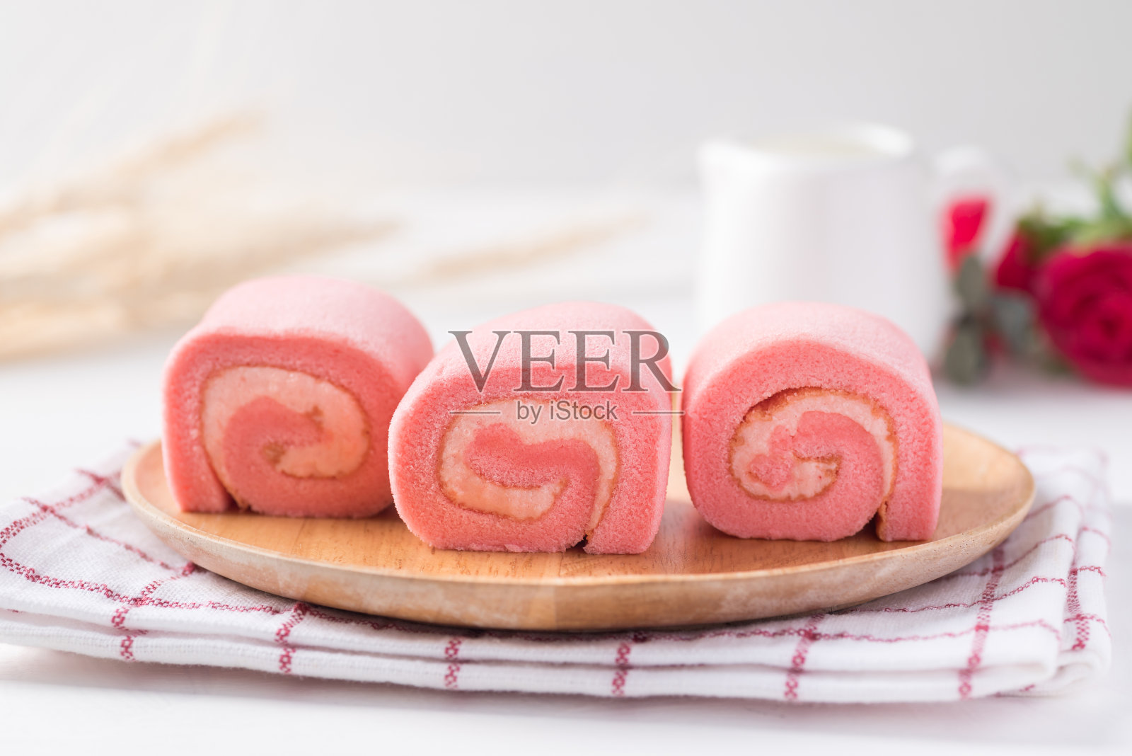 粉红草莓卷蛋糕或瑞士卷,配以鲜奶油和草莓口味照片摄影图片