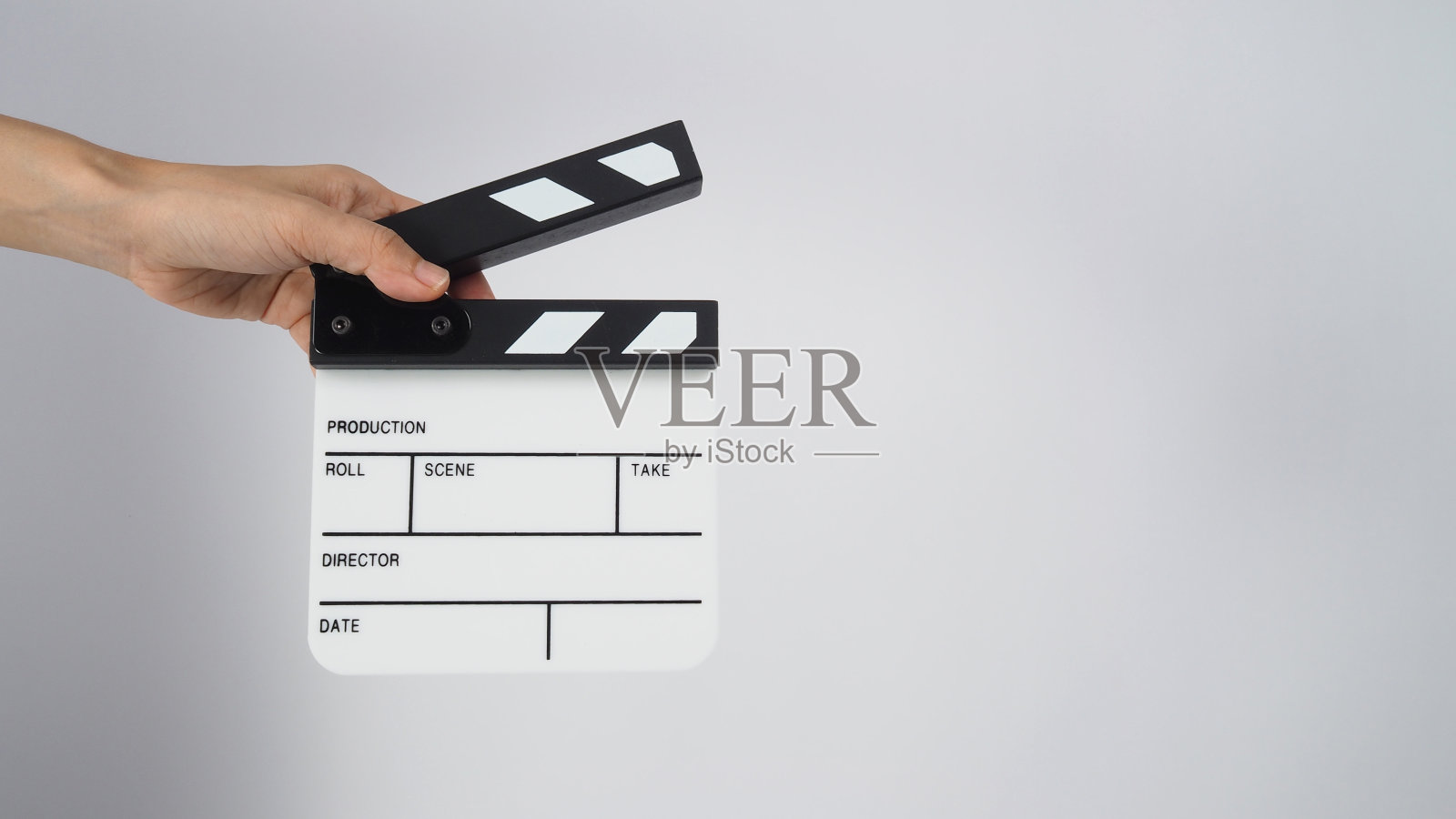 手握拍板或电影板。它适用于视频制作,电影,电影行业的白色背景。照片摄影图片