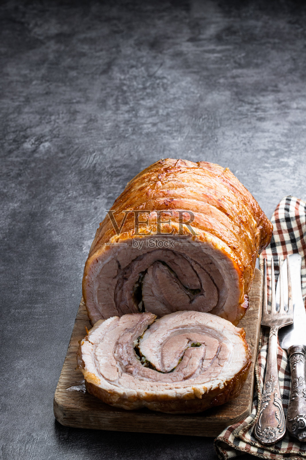 烤猪肉卷与香草和香料在灰色的石头背景照片摄影图片