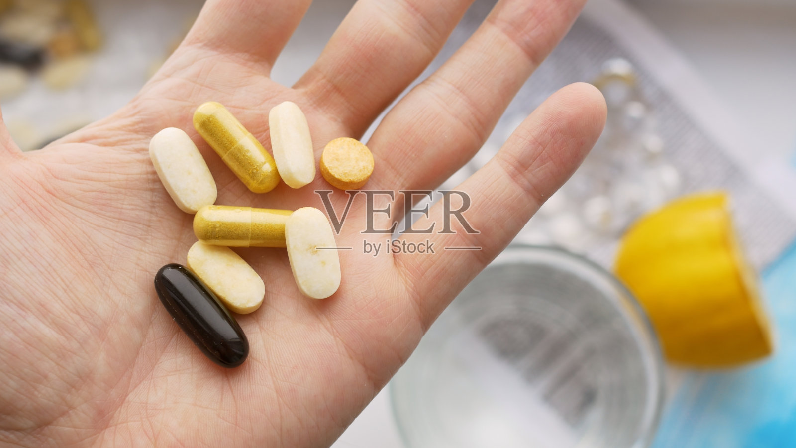 在你的手掌中有许多不同的药片和药片,有助于对抗疾病和冠状病毒。医生给她开了一些药来帮助她恢复和维持健康照片摄影图片