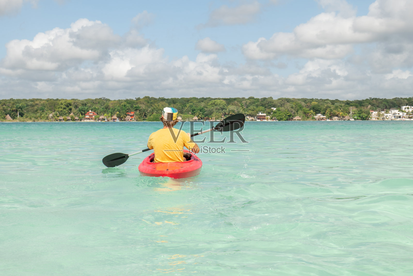 男游客在热带泻湖上划独木舟,享受国外的假期照片摄影图片