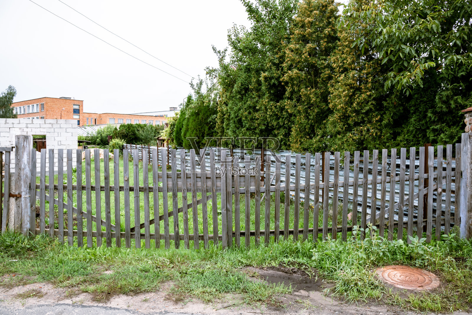 老木栅栏。建设的一面。夏天的季节。透明的木制对冲。未完成的建筑照片摄影图片