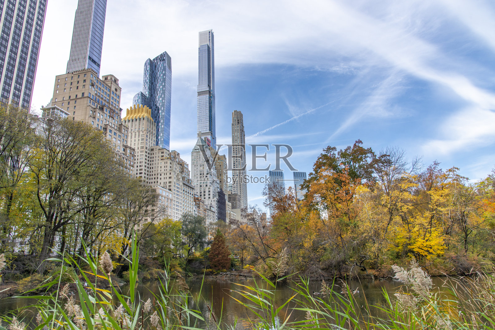 秋天的一天,在美国纽约曼哈顿的一个彩色中央公园的池塘和建筑物。照片摄影图片