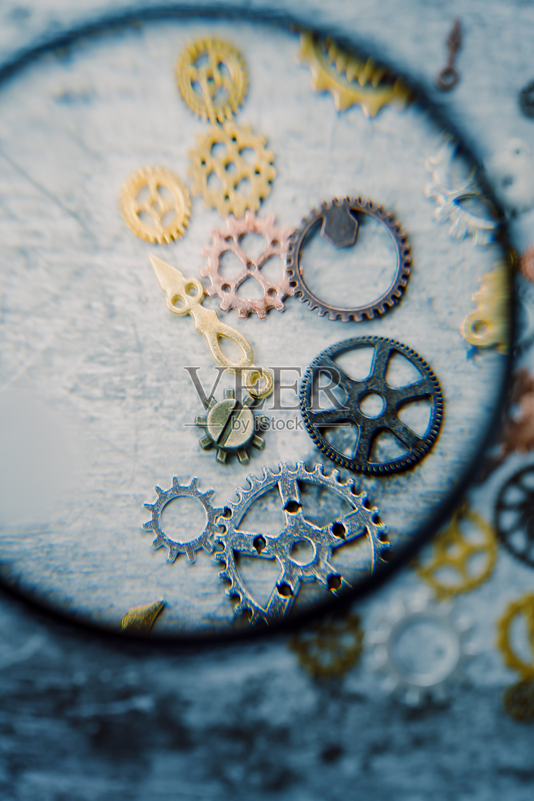 用放大镜看石板上的齿轮照片摄影图片