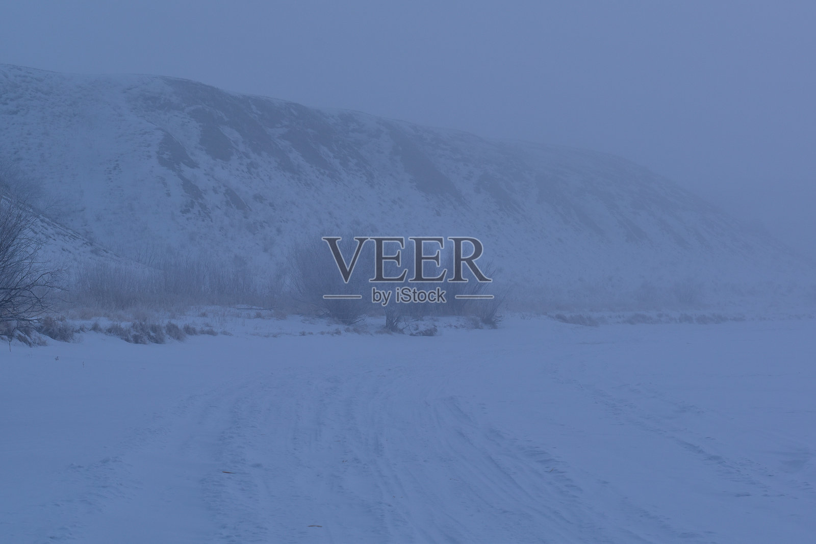 一个雾气蒙蒙的冬天清晨,在陡峭的河岸上。冬天的风景照片摄影图片