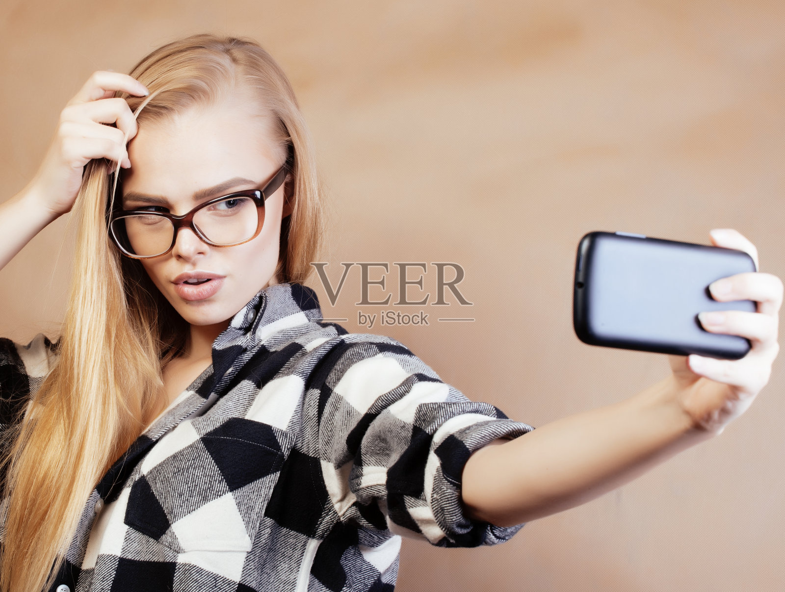 年轻漂亮的女孩十几岁,戴着眼镜在学校自拍,背着背包的学生,生活方式和人的概念照片摄影图片