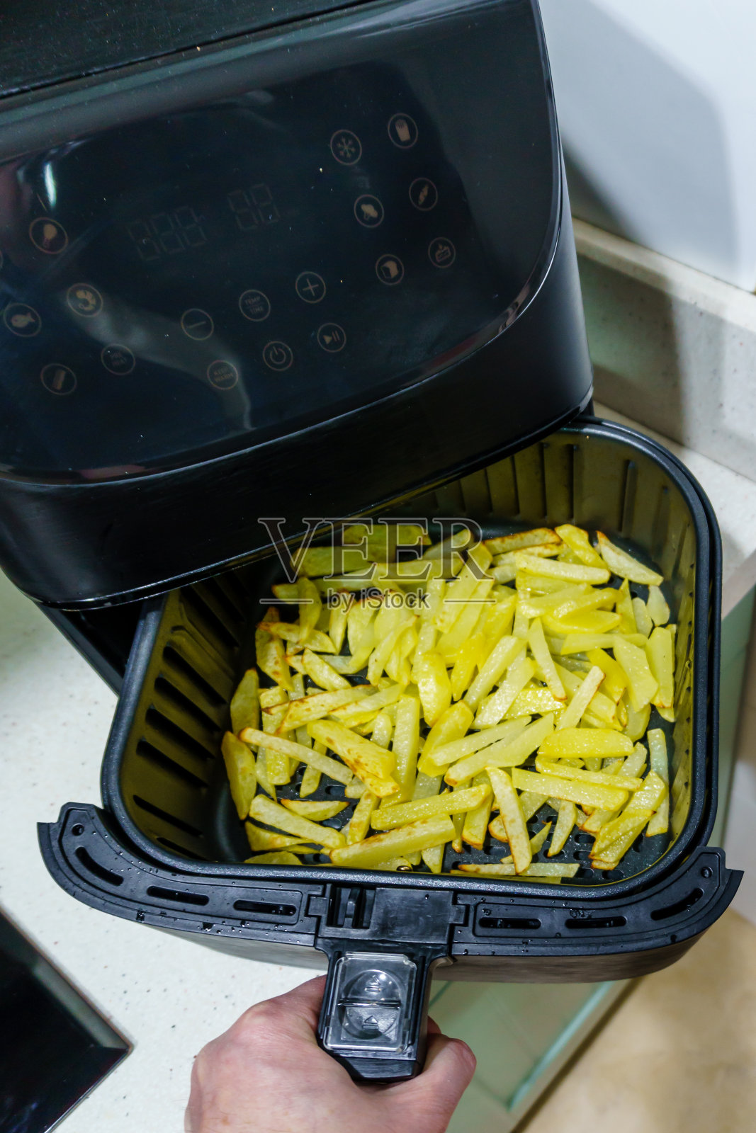 用空气炸锅自制的炸薯条。无油健康烹饪理念照片摄影图片